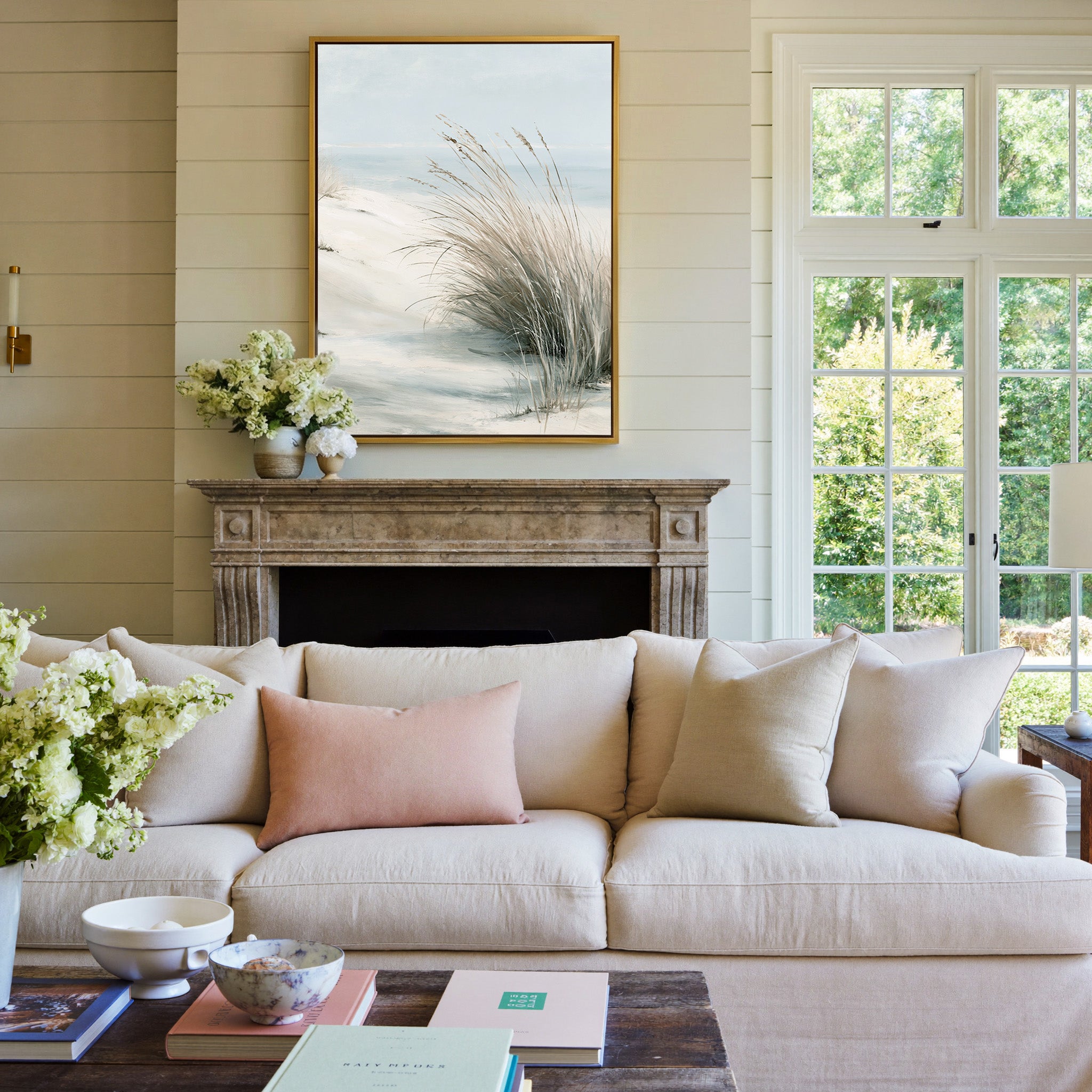 pale dune grass over soft blue water canvas wall art in a gold frame above a mantel