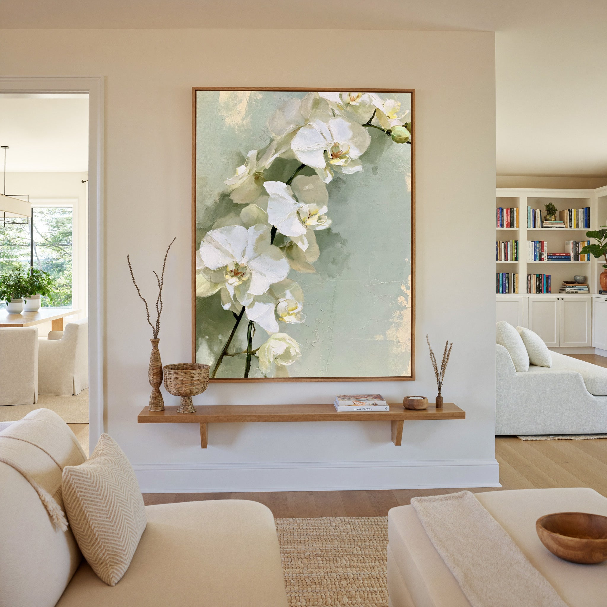 white orchids with long stems on a pale green canvas wall art in an oak frame in a living room