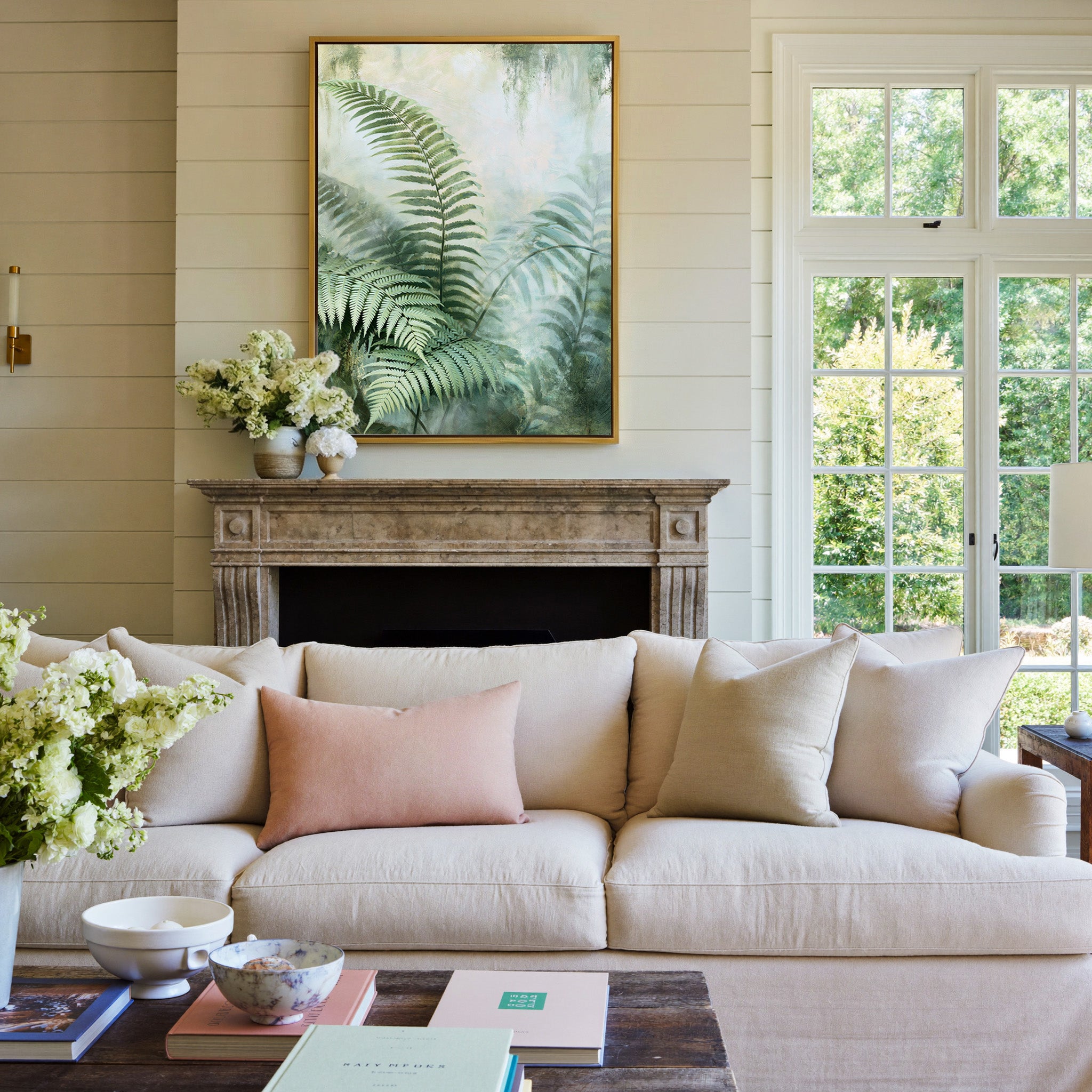 layered green fern fronds in a misty pale canvas wall art in a gold frame above a mantel
