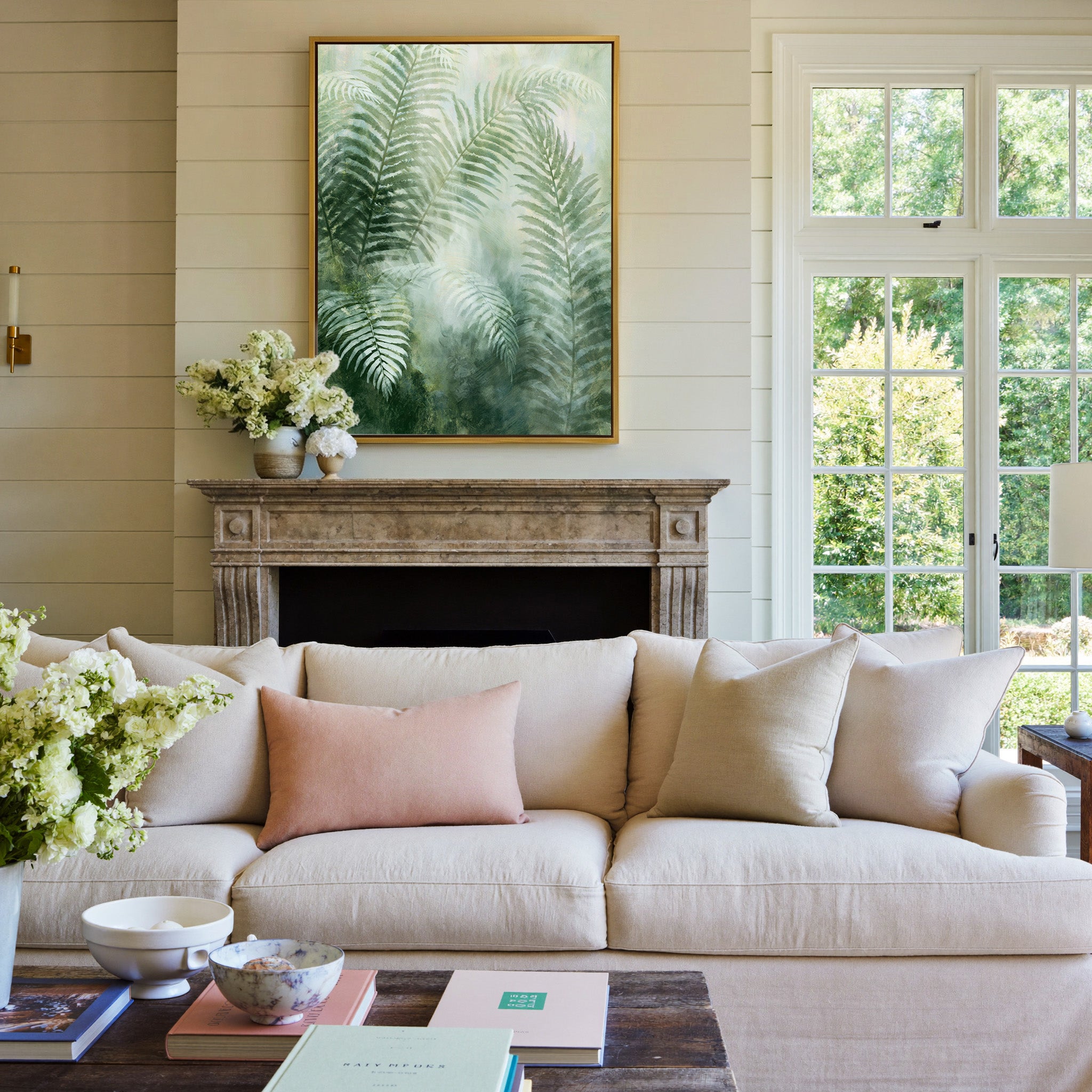 soft green fern fronds over a misty pale ground canvas wall art in a gold frame above a mantel