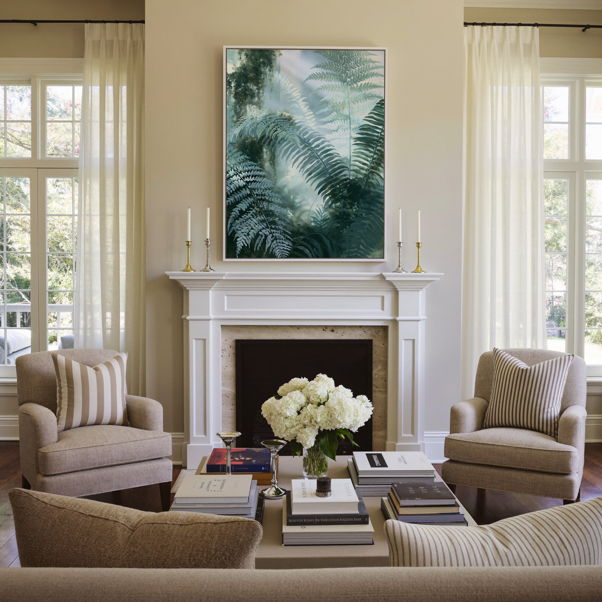 soft green fern fronds over a misted blue gray canvas wall art in a white frame above a mantel