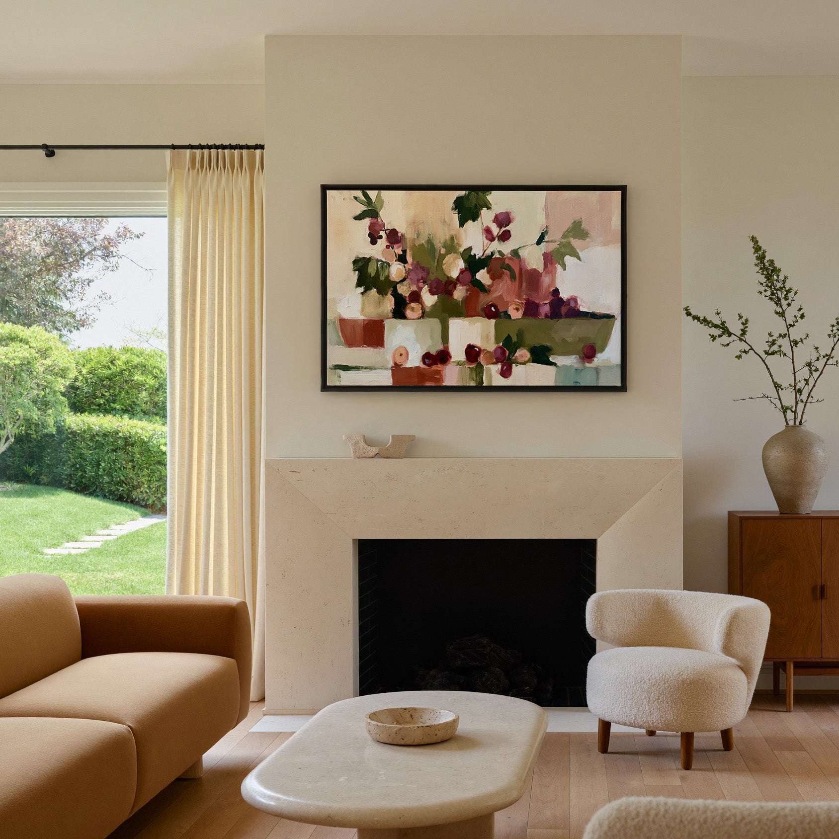 warm abstract still life with grapes and leafy canvas wall art in a black frame above a mantel