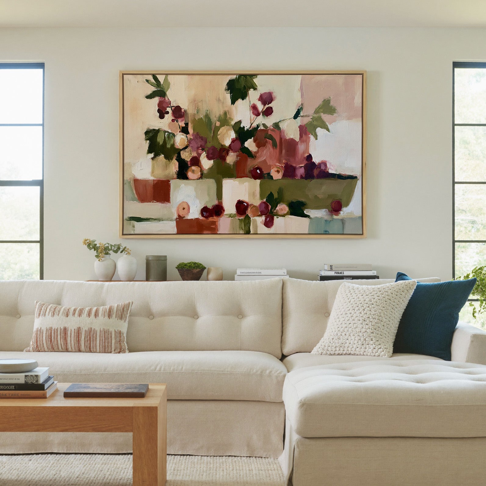 warm abstract still life with grapes and leafy canvas wall art in a natural wood frame in a living room