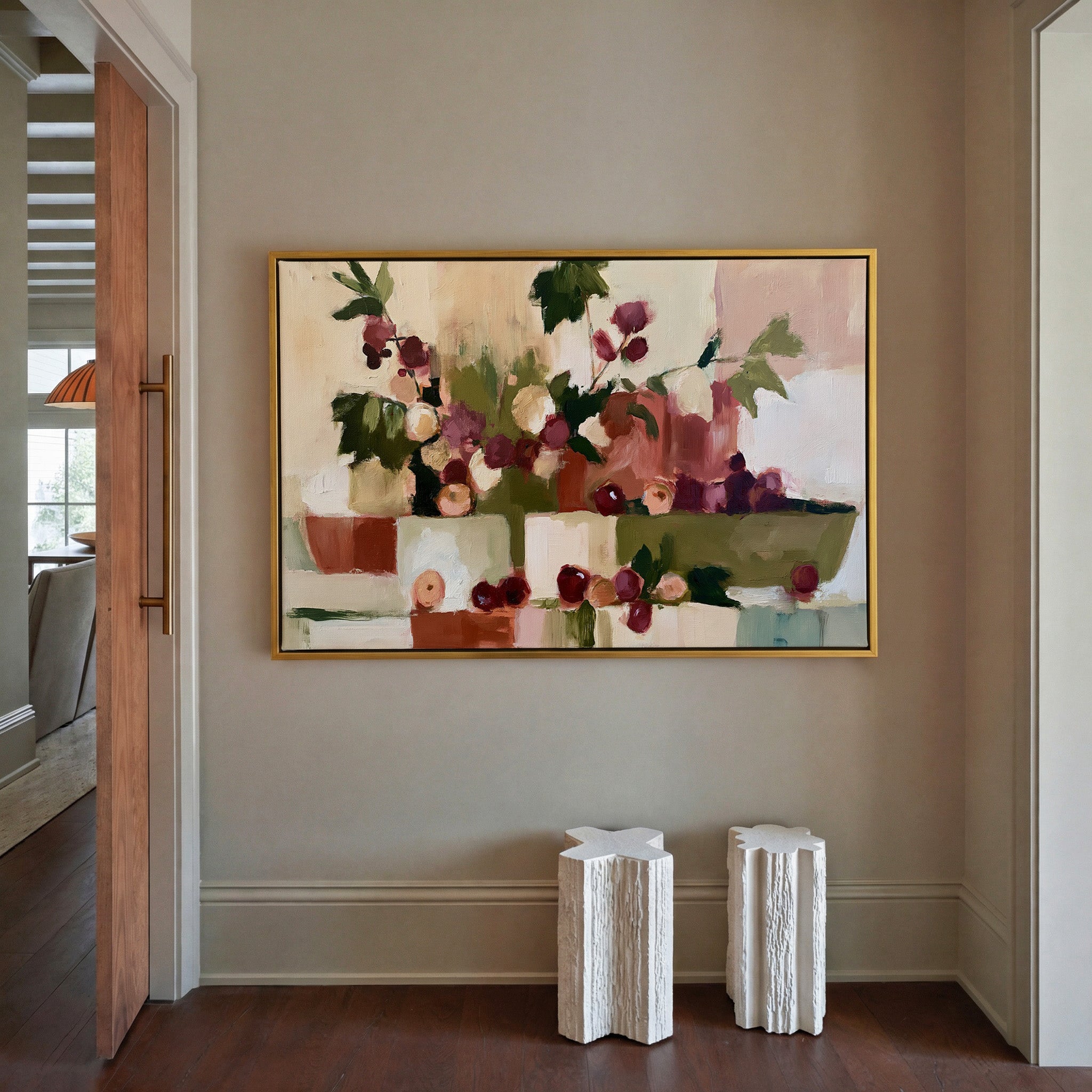 warm abstract still life with grapes and leafy canvas wall art in a gold frame in a styled room setting