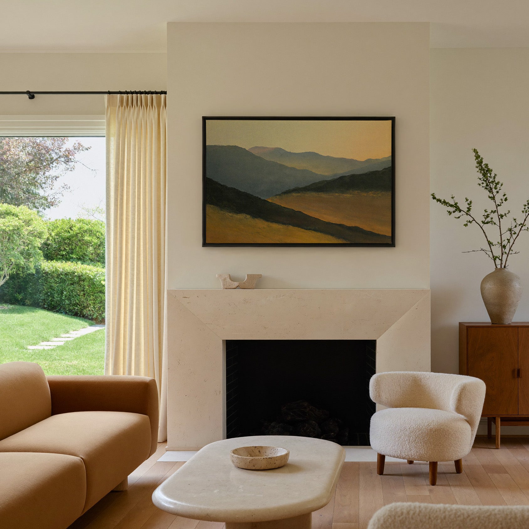 layered mountain ridges at sunset canvas wall art in a black frame above a mantel