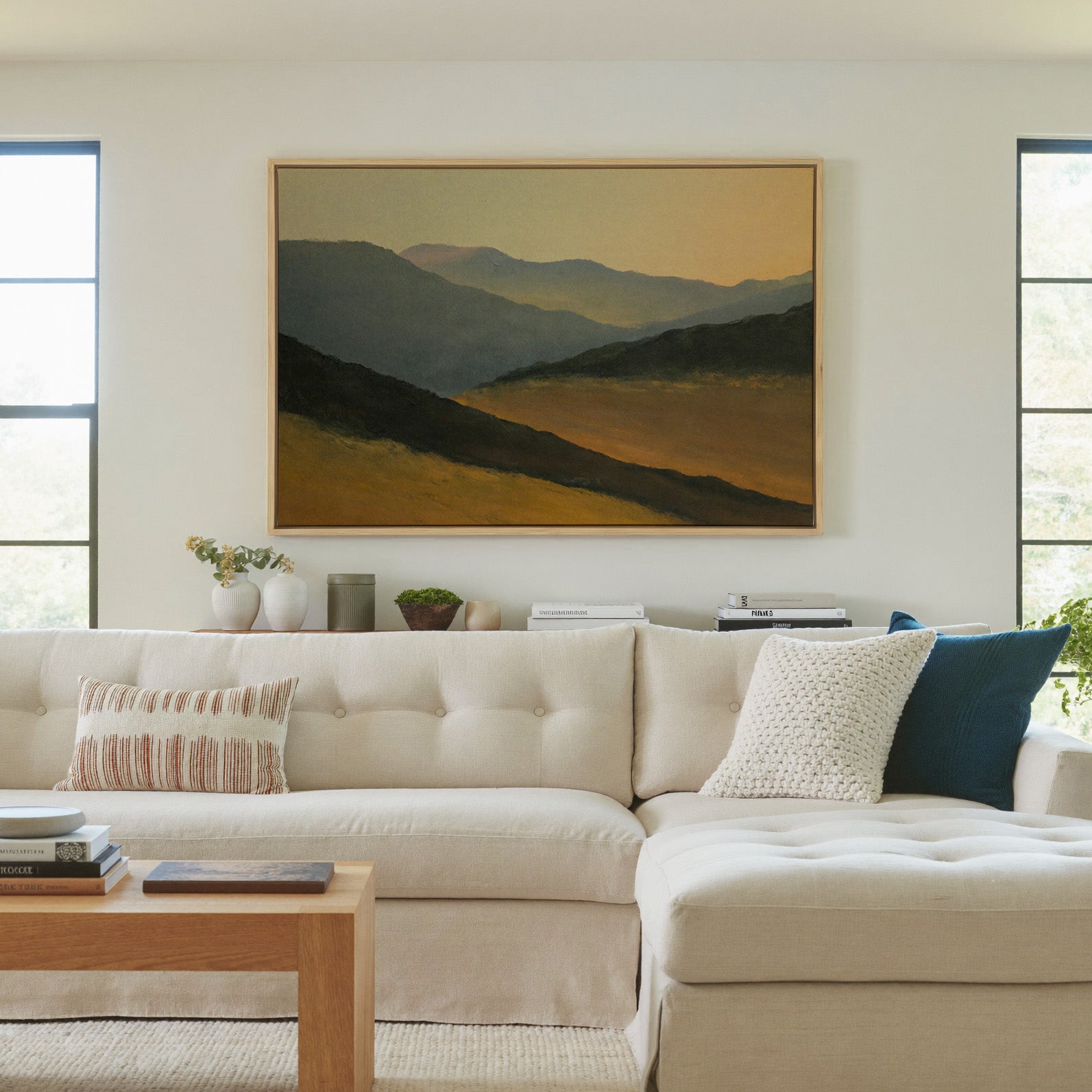 layered mountain ridges at sunset canvas wall art in a natural wood frame in a living room