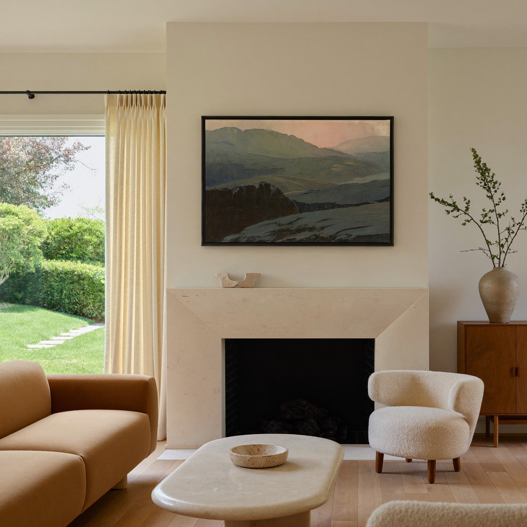 misty mountain landscape with dark foreground canvas wall art in a black frame above a mantel