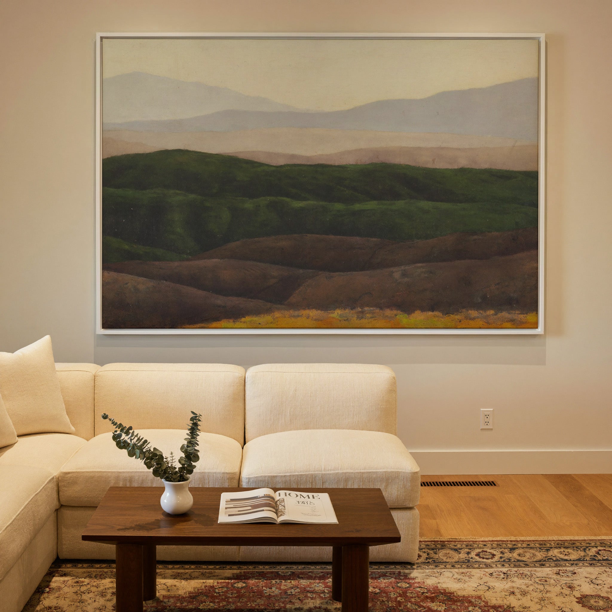 layered green hills with pale distant mountains canvas wall art in a white frame in a styled room setting