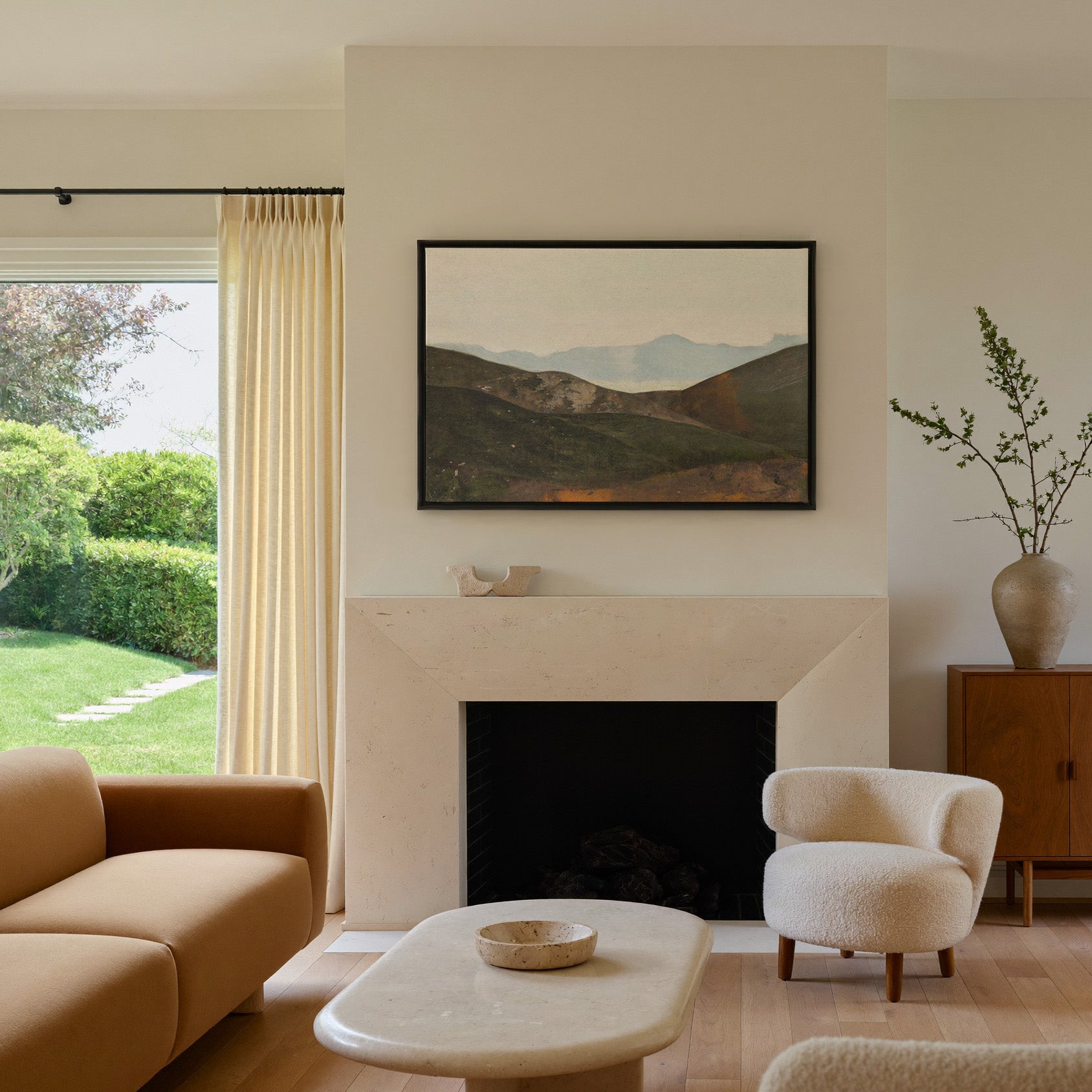soft blue mountain landscape with dark canvas wall art in a black frame above a mantel