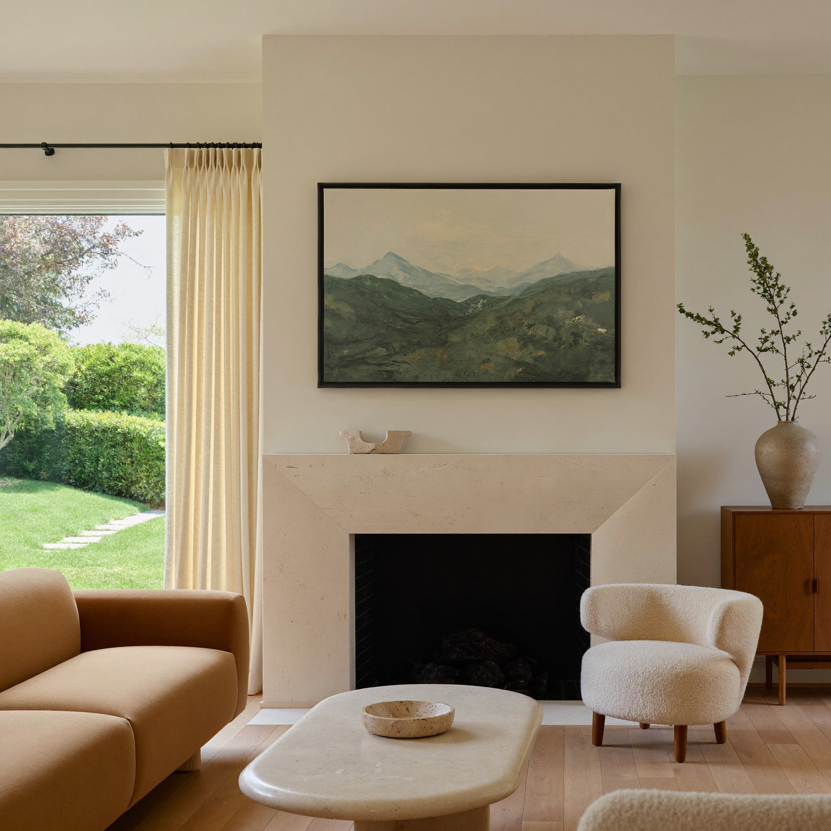 soft green mountain landscape with pale peaks canvas wall art in a black frame above a mantel