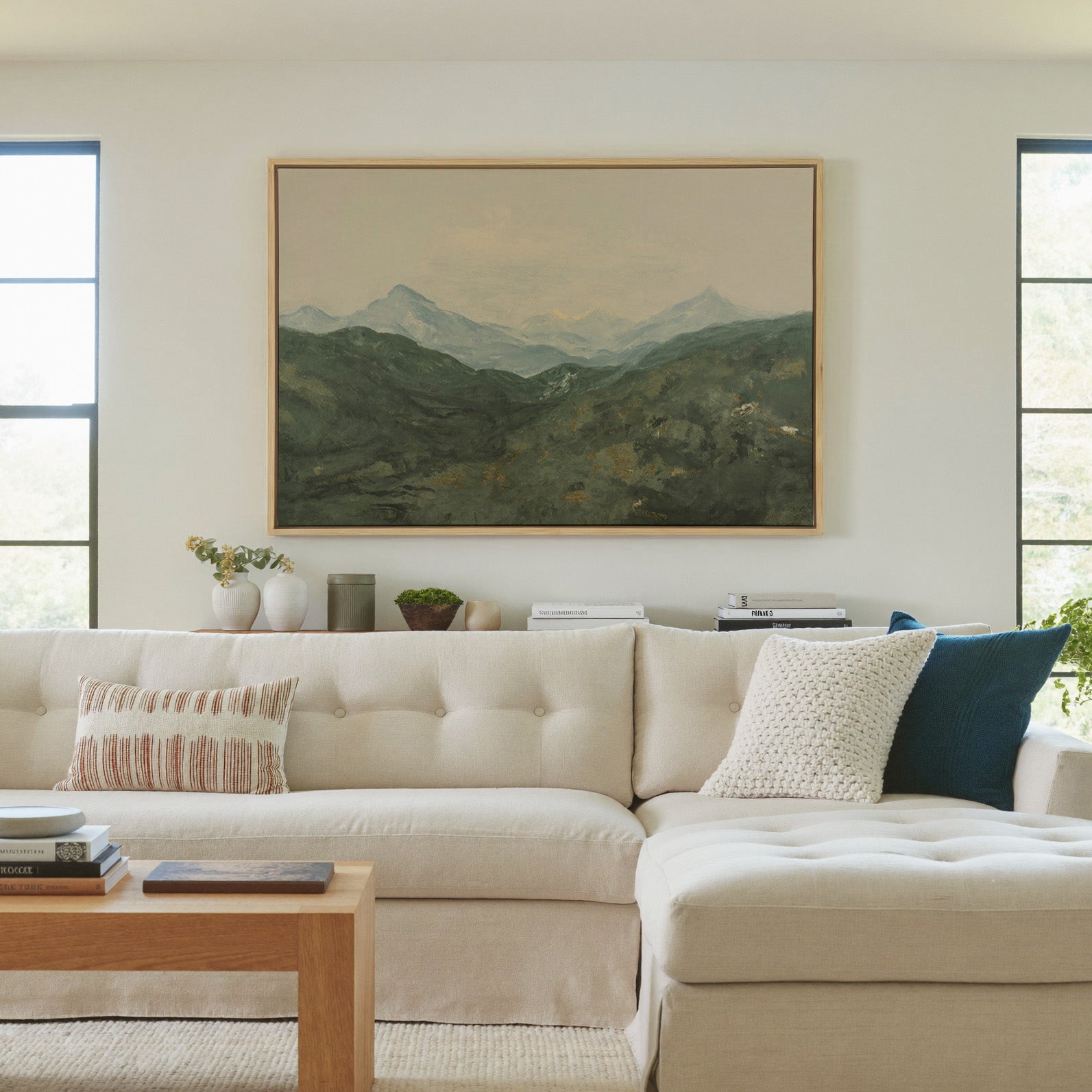 soft green mountain landscape with pale peaks canvas wall art in a natural wood frame in a living room