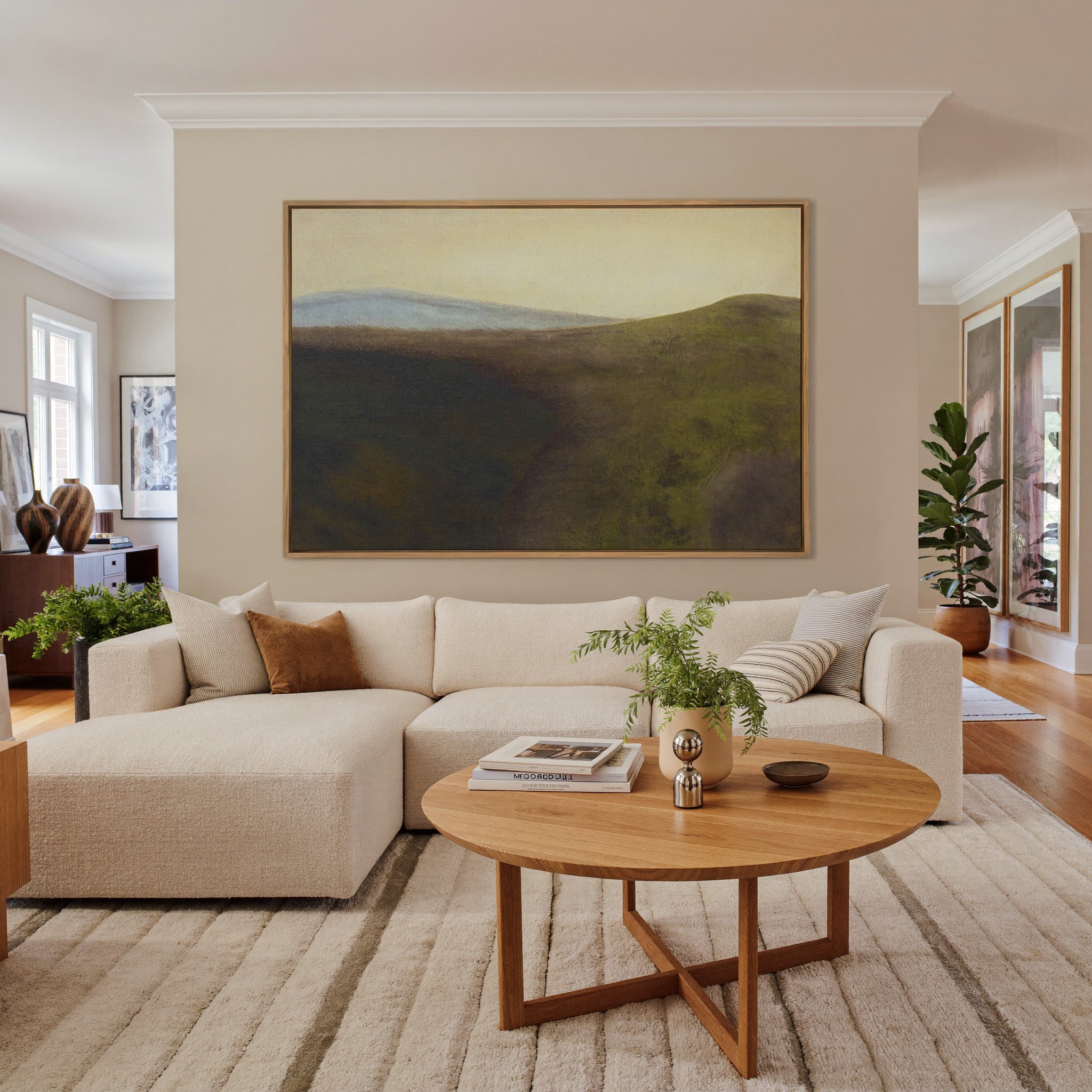 muted green hills with a pale blue ridge and canvas wall art in an oak frame in a living room