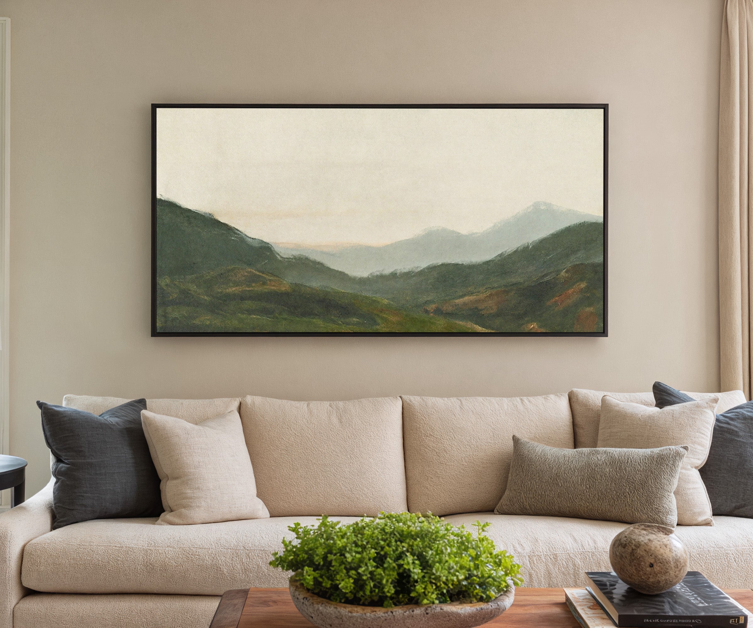 misty green mountain landscape canvas wall art in a black frame in a styled room setting