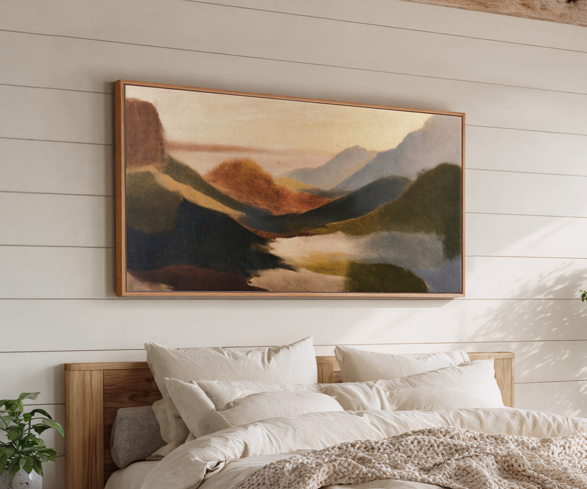 layered coastal landscape with dark headlands, canvas wall art in an oak frame above a bed