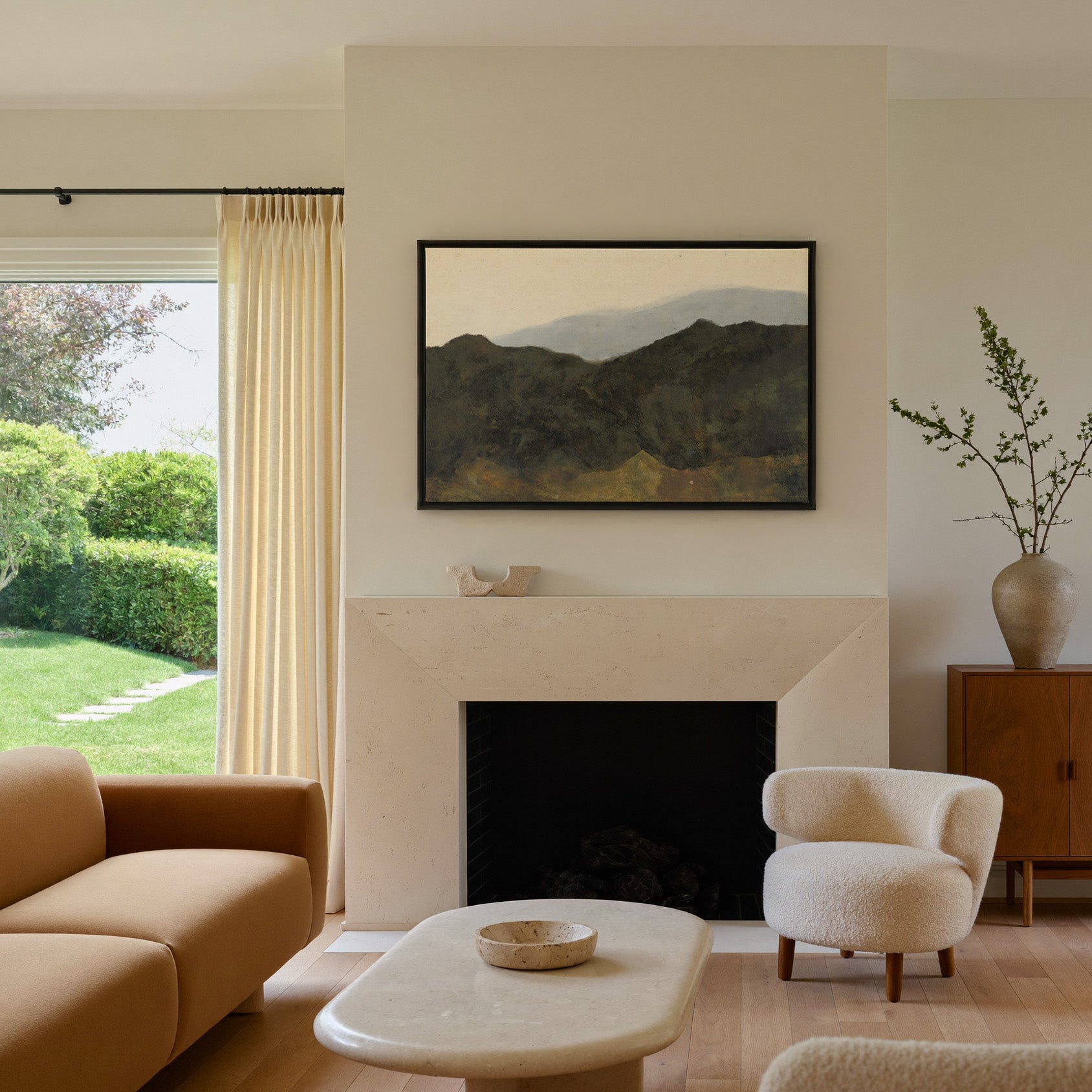 dark mountain ridges beneath a pale hazy sky canvas wall art in a black frame above a mantel