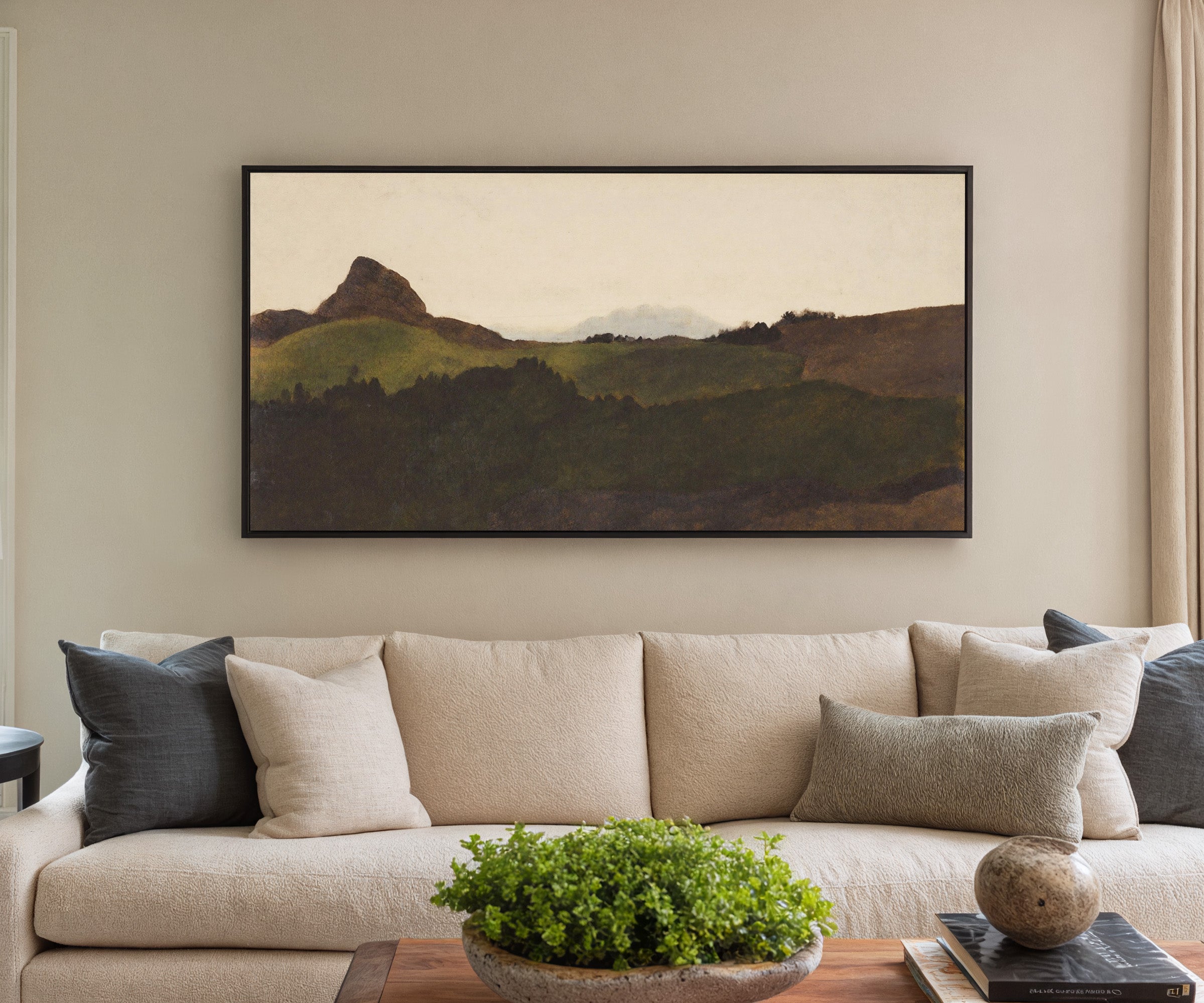 dark green hills with a pale distant peak canvas wall art in a black frame in a styled room setting