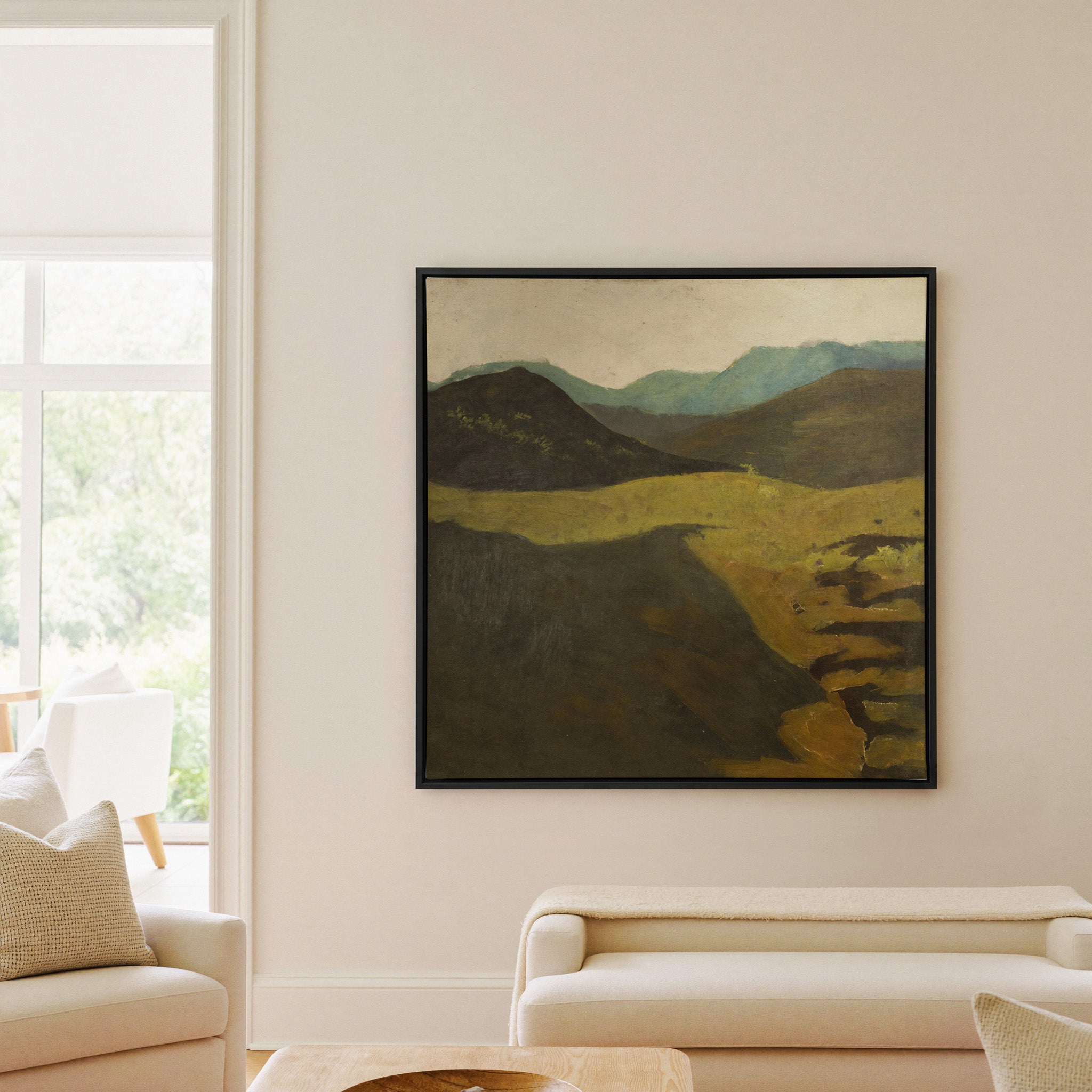 muted mountain landscape with dark foreground canvas wall art in a black frame in a living room