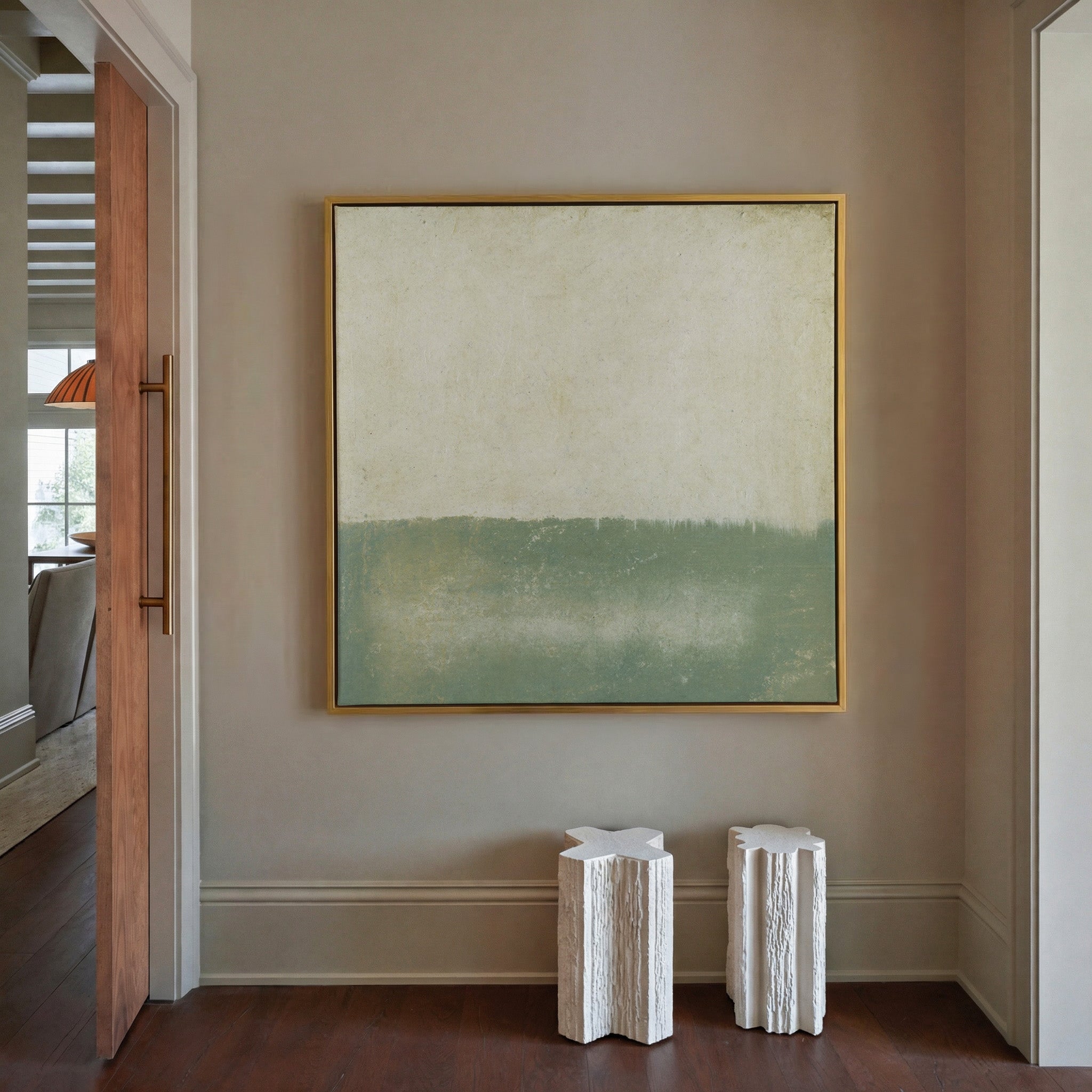 soft sage and cream abstract with a low canvas wall art in a gold frame in a styled room setting