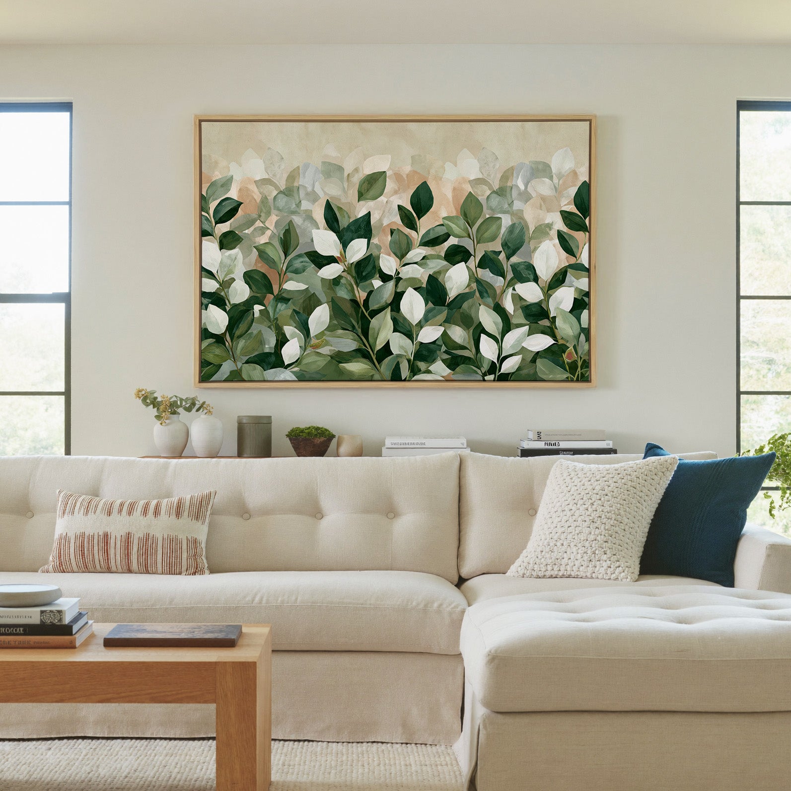 overlapping green and cream leaves canvas wall art in a natural wood frame in a living room