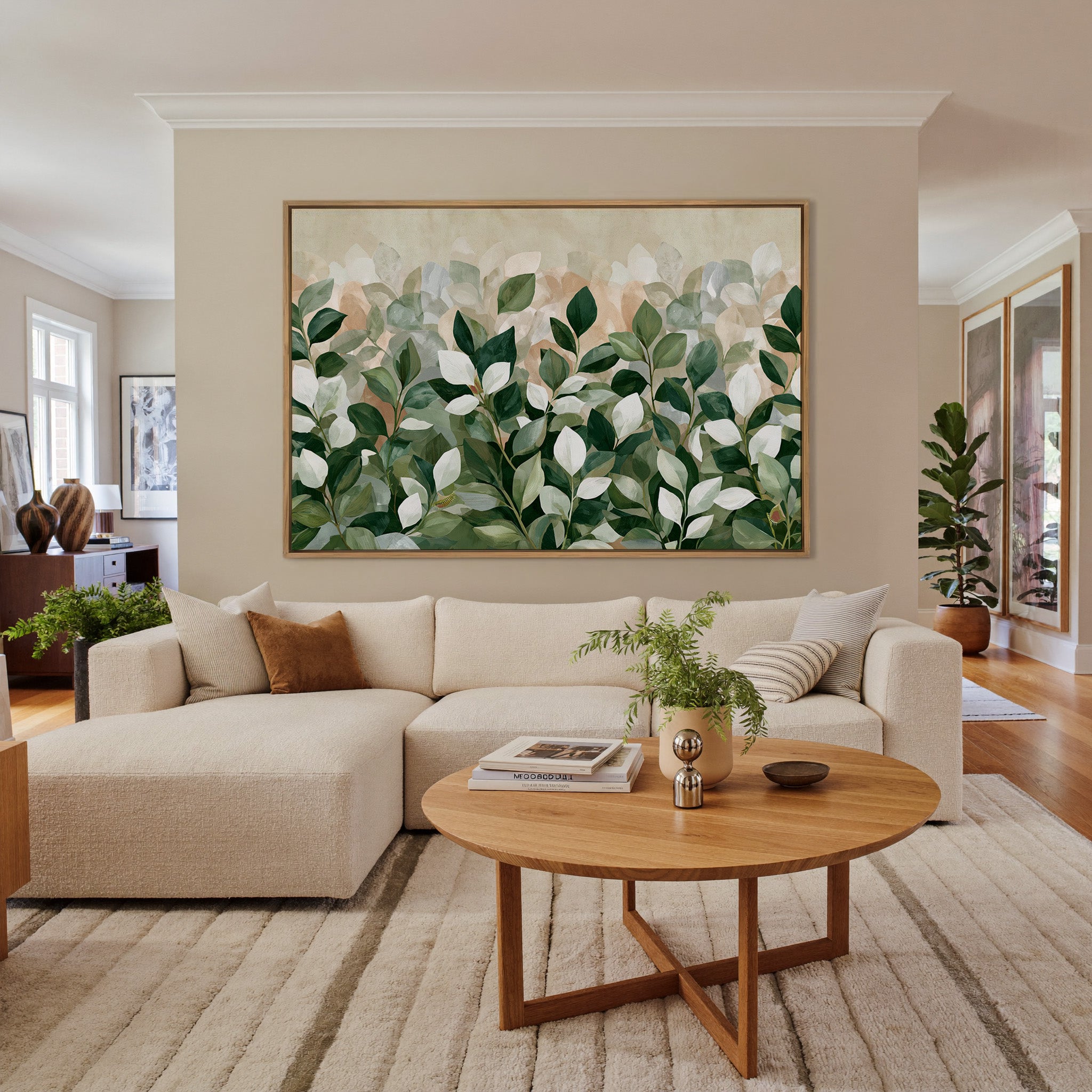 overlapping green and cream leaves canvas wall art in an oak frame in a living room