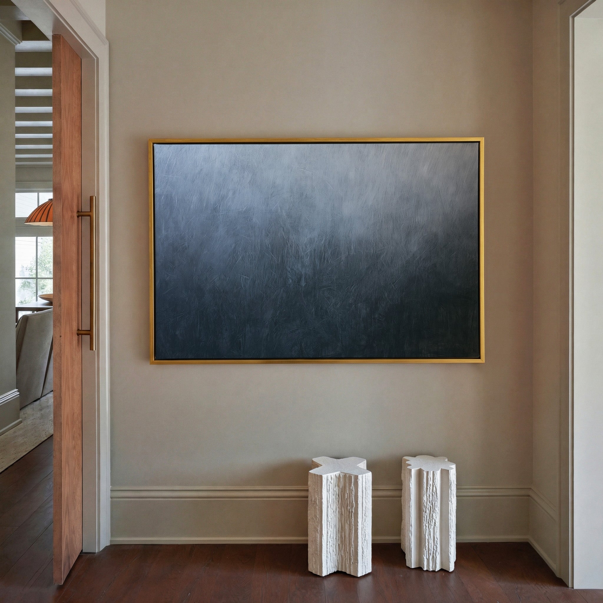 cool blue gray abstract with soft vertical canvas wall art in a gold frame in a styled room setting