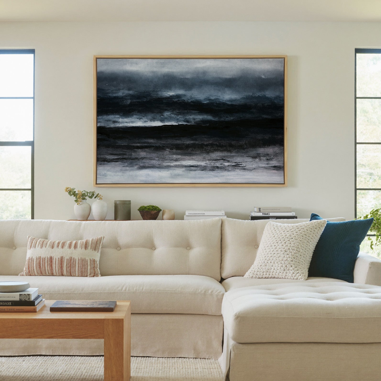 dark black and navy abstract with layered canvas wall art in a natural wood frame in a living room
