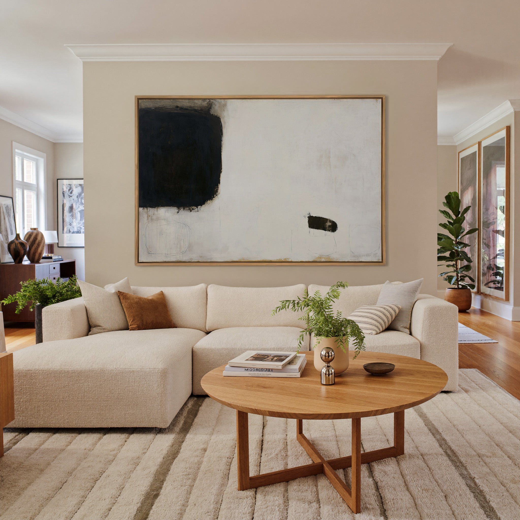 sparse black and cream abstract with heavy dark canvas wall art in an oak frame in a living room
