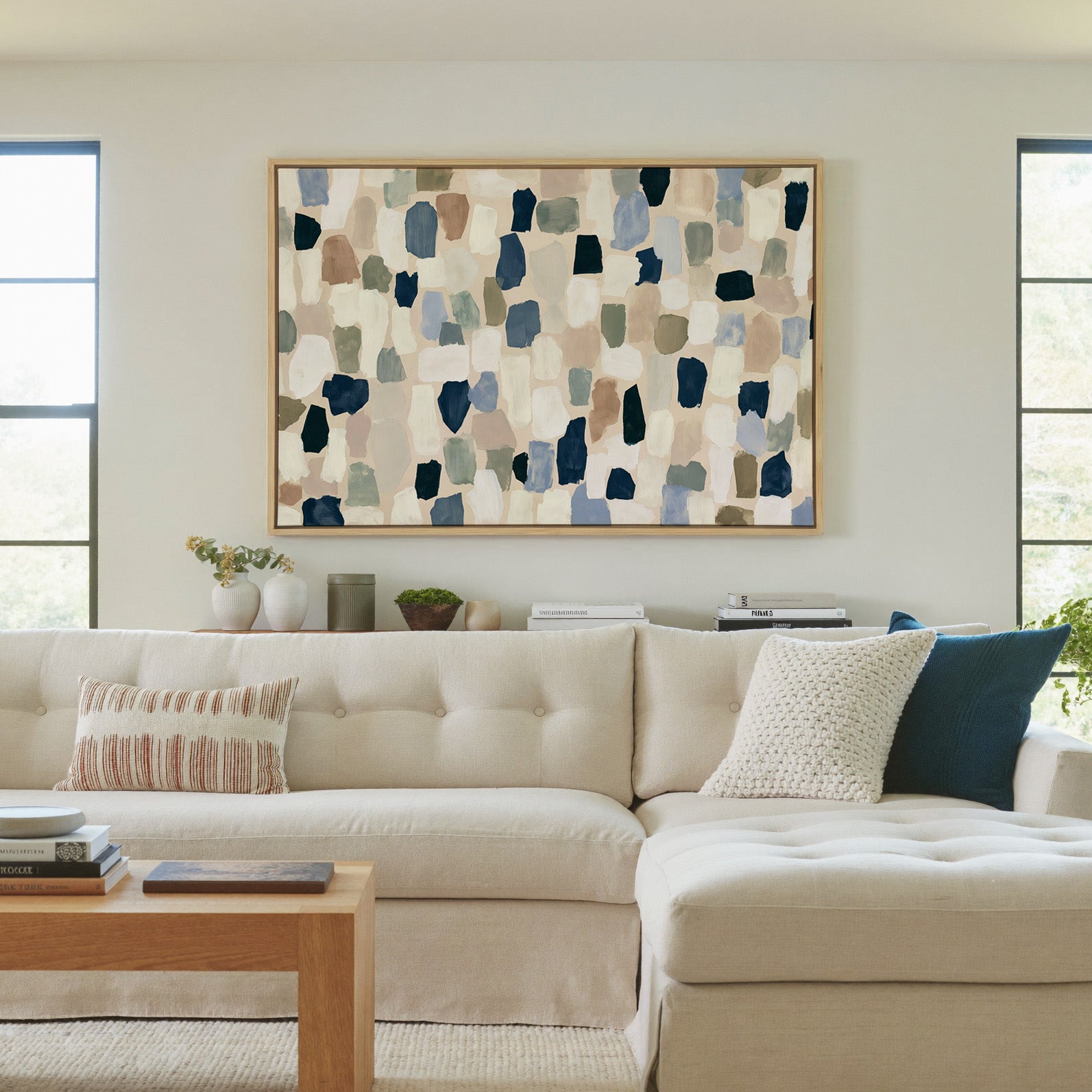warm stone abstract with drifting hand cut canvas wall art in a natural wood frame in a living room