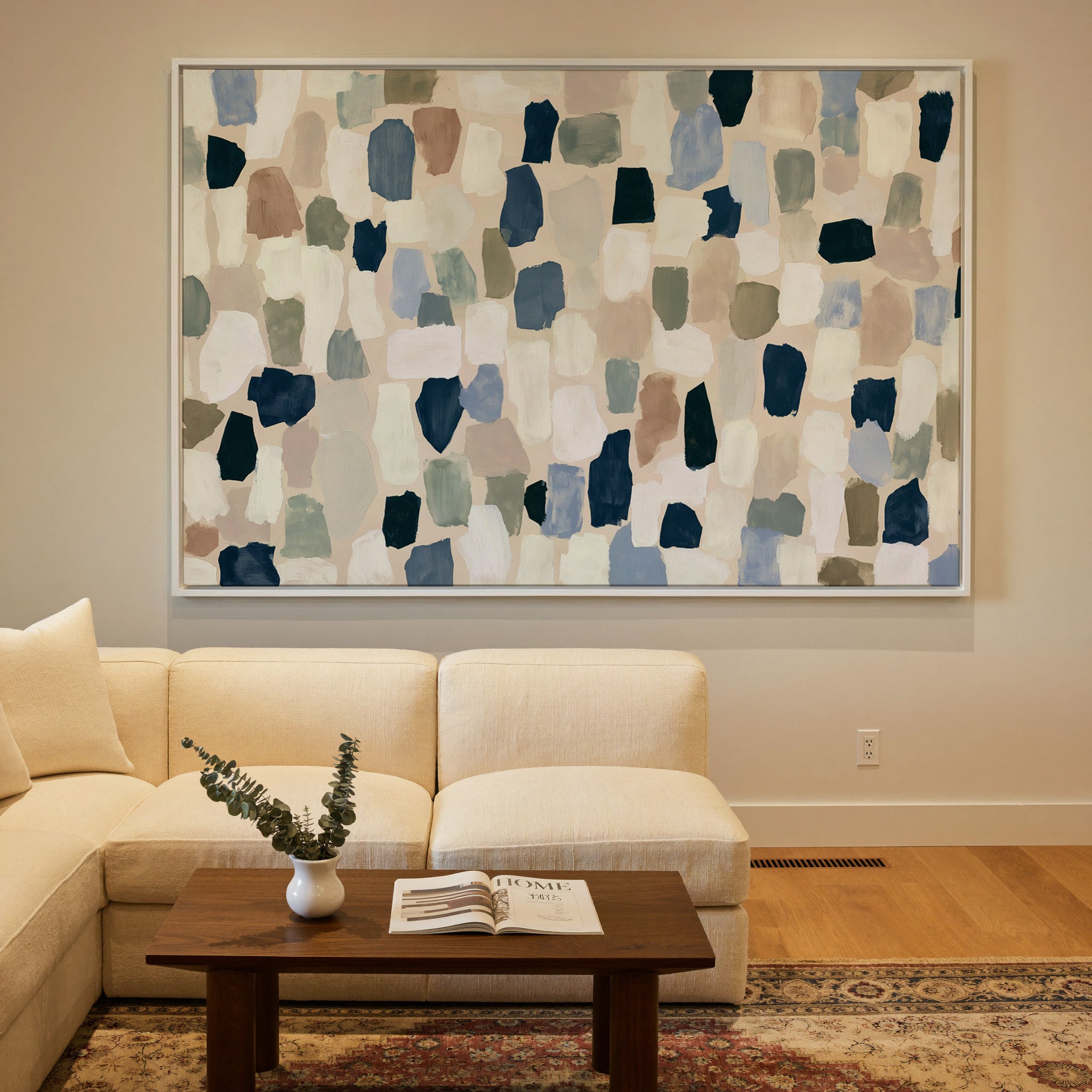 warm stone abstract with drifting hand cut canvas wall art in a white frame in a styled room setting