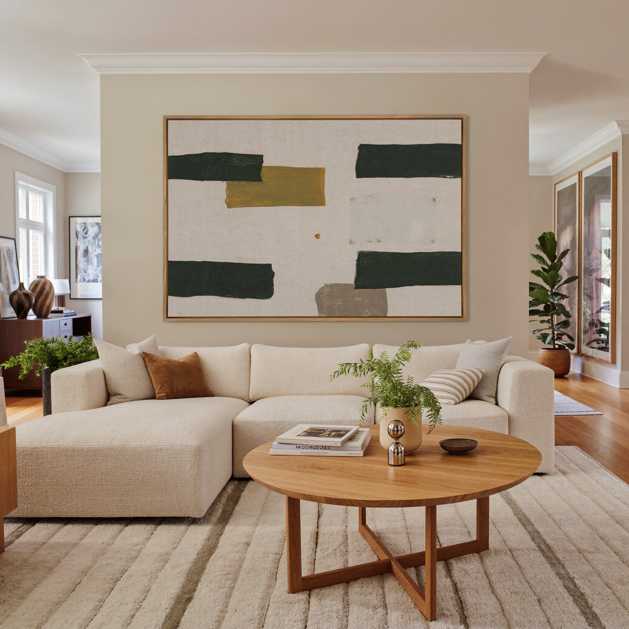 cream abstract with dark green blocks and a canvas wall art in an oak frame in a living room