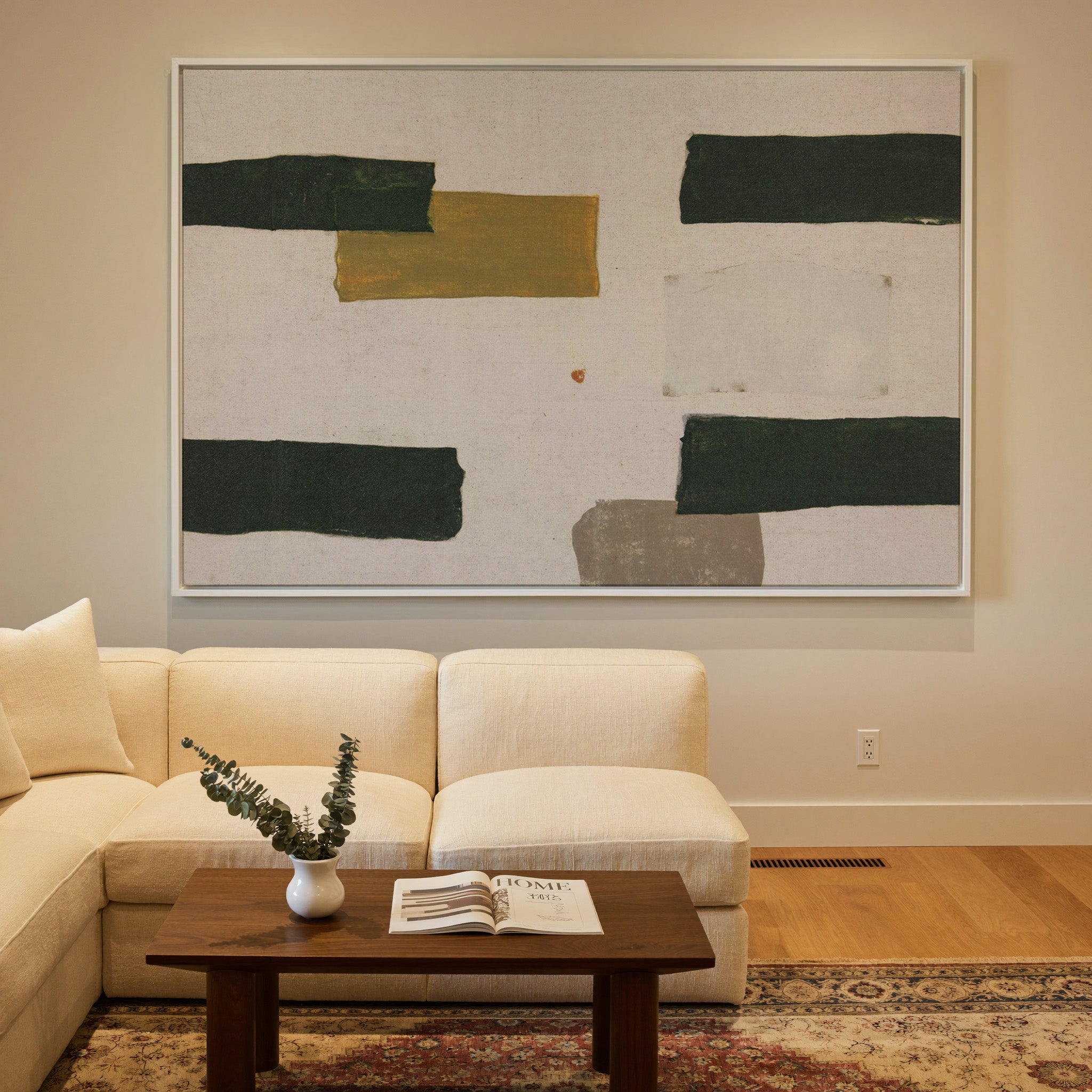 cream abstract with dark green blocks and a canvas wall art in a white frame in a styled room setting