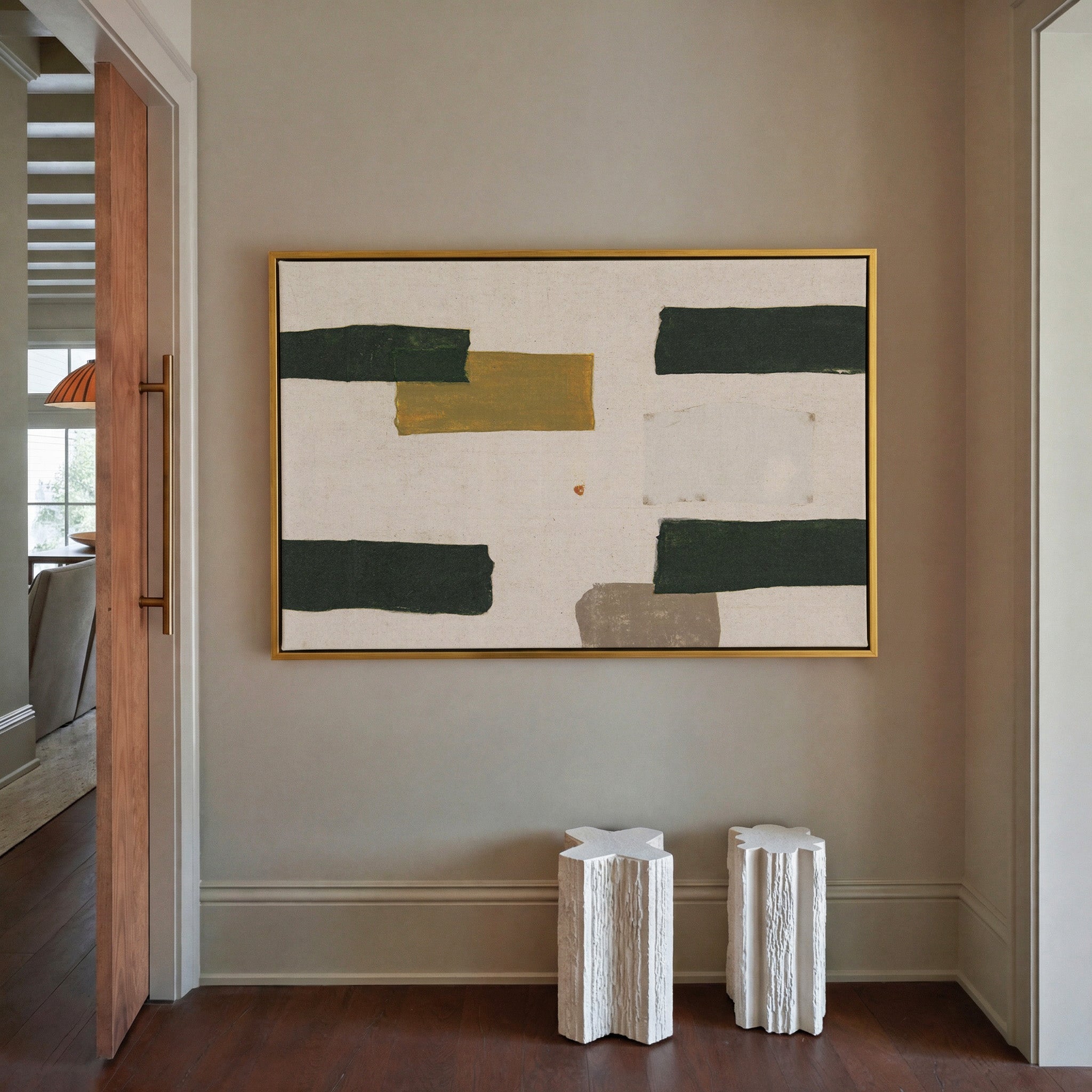 cream abstract with dark green blocks and a canvas wall art in a gold frame in a styled room setting