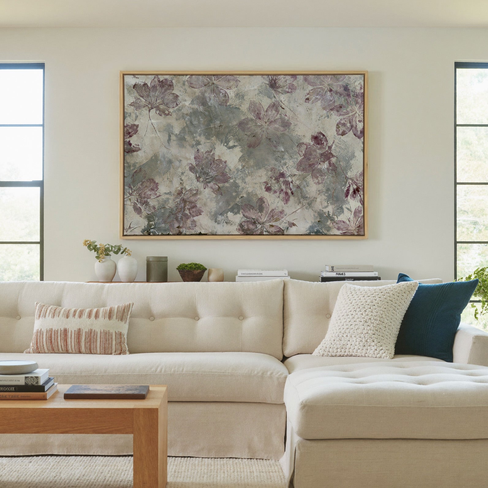 muted floral abstract with mauve blossoms on a canvas wall art in a natural wood frame in a living room