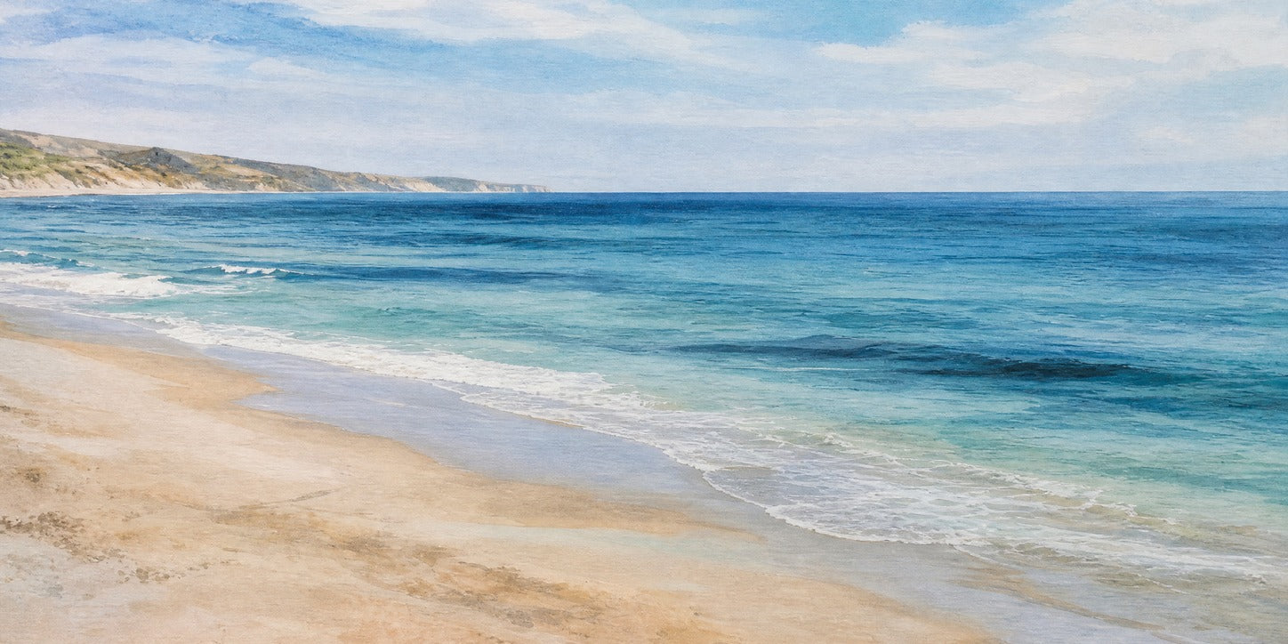 Pale sand, turquoise surf, and a low headland beneath a bright clouded sky