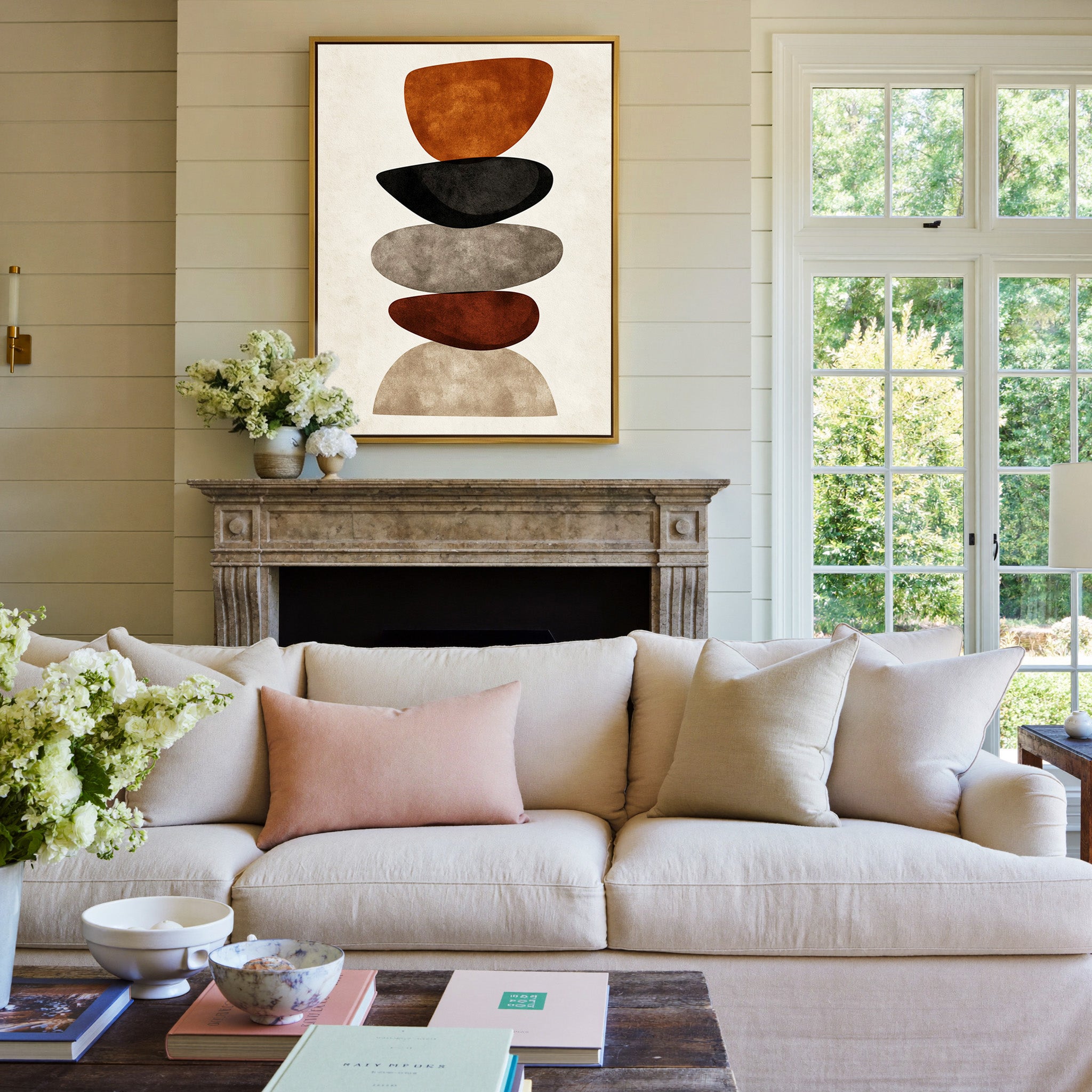 stacked organic shapes in rust, black, taupe, canvas wall art in a gold frame above a mantel