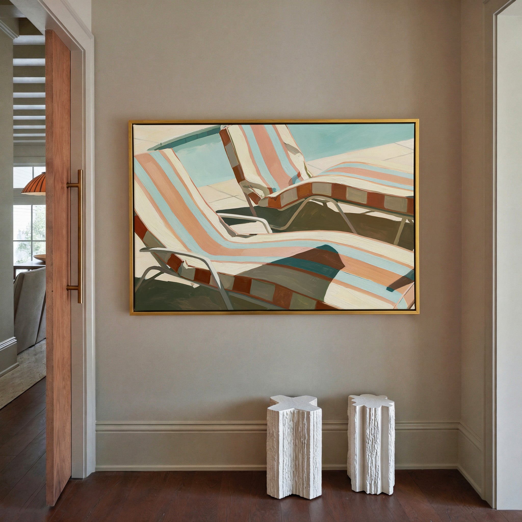 sun faded striped lounge chairs canvas wall art in a gold frame in a styled room setting