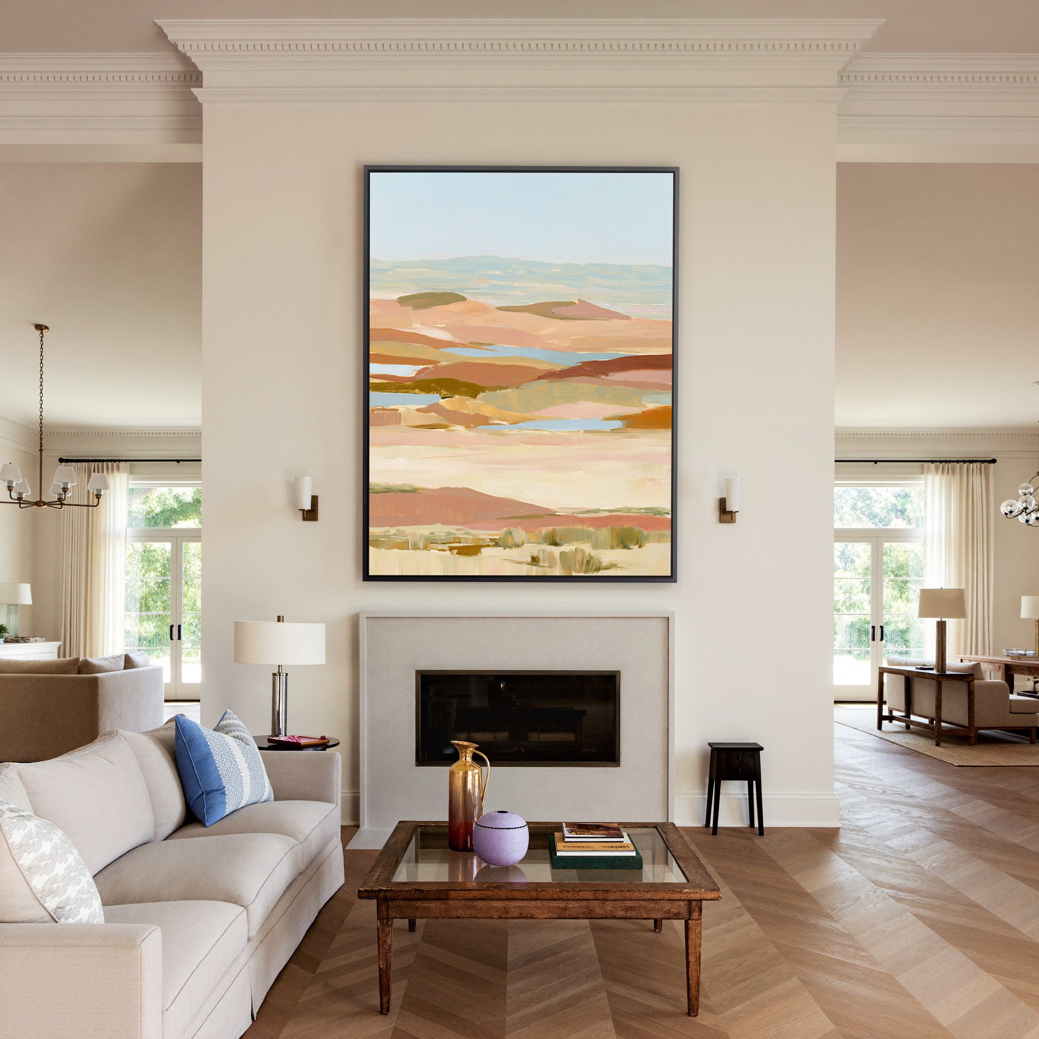 soft desert hills in blush, sand, blue, and canvas wall art in a black frame above a mantel