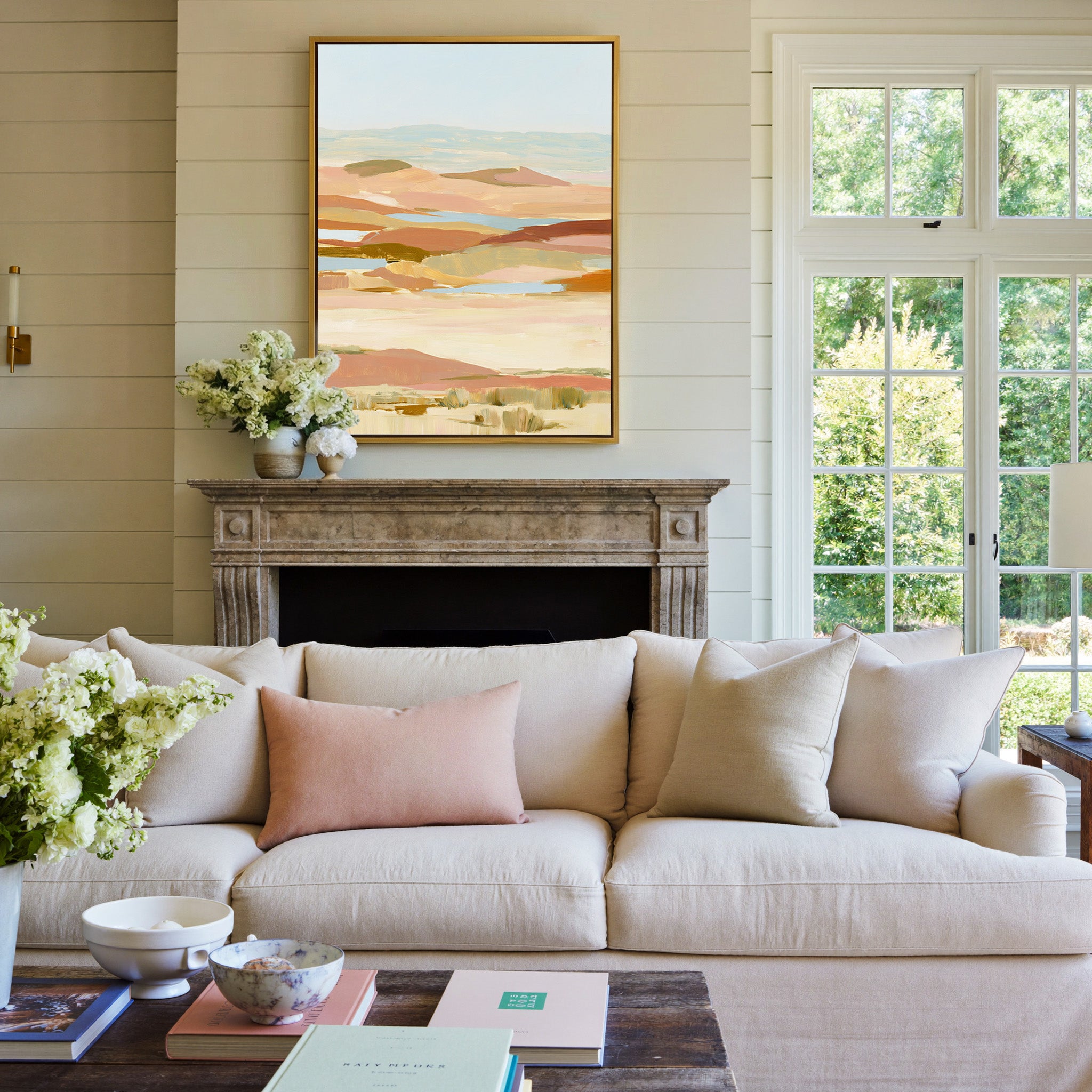 soft desert hills in blush, sand, blue, and canvas wall art in a gold frame above a mantel