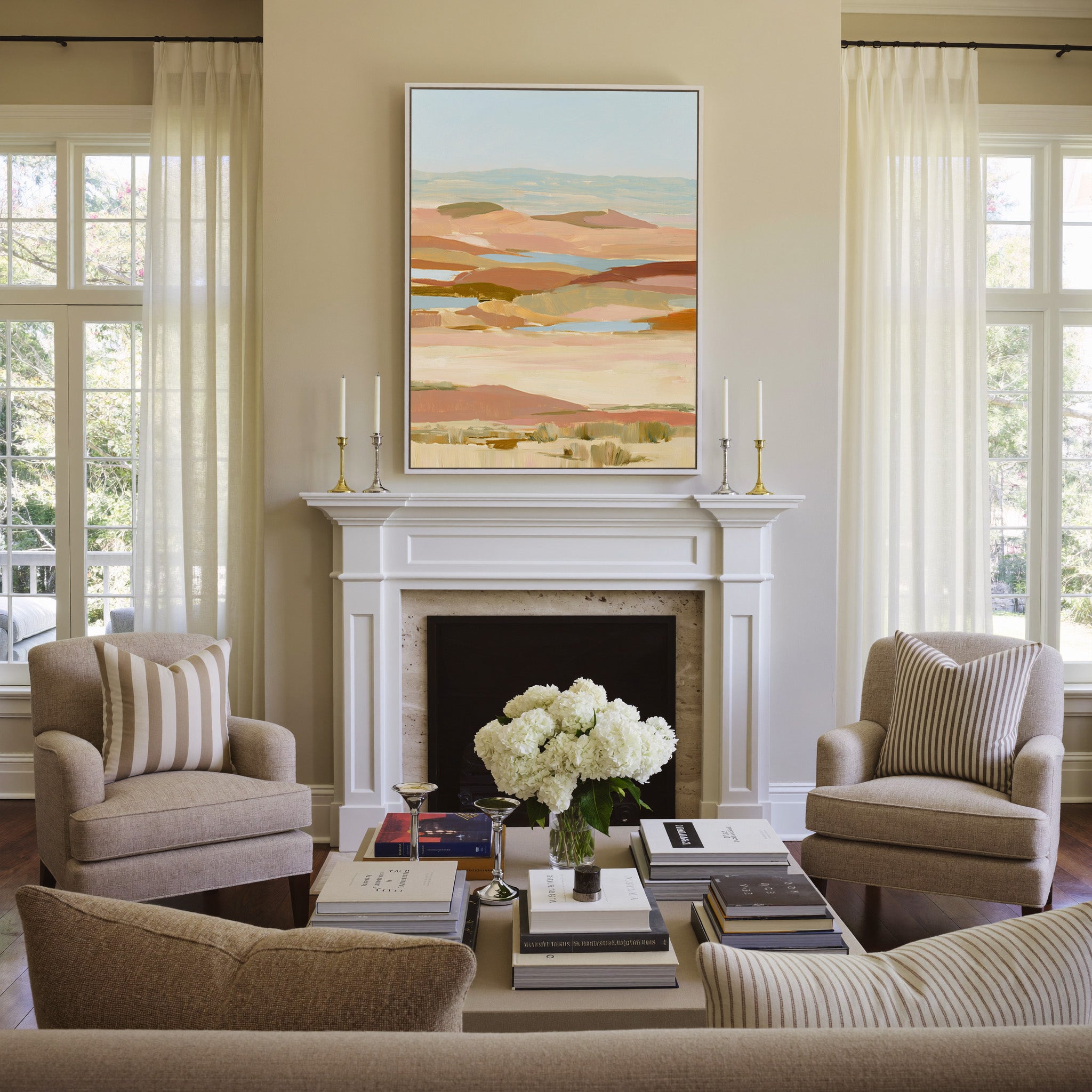 soft desert hills in blush, sand, blue, and canvas wall art in a white frame above a mantel