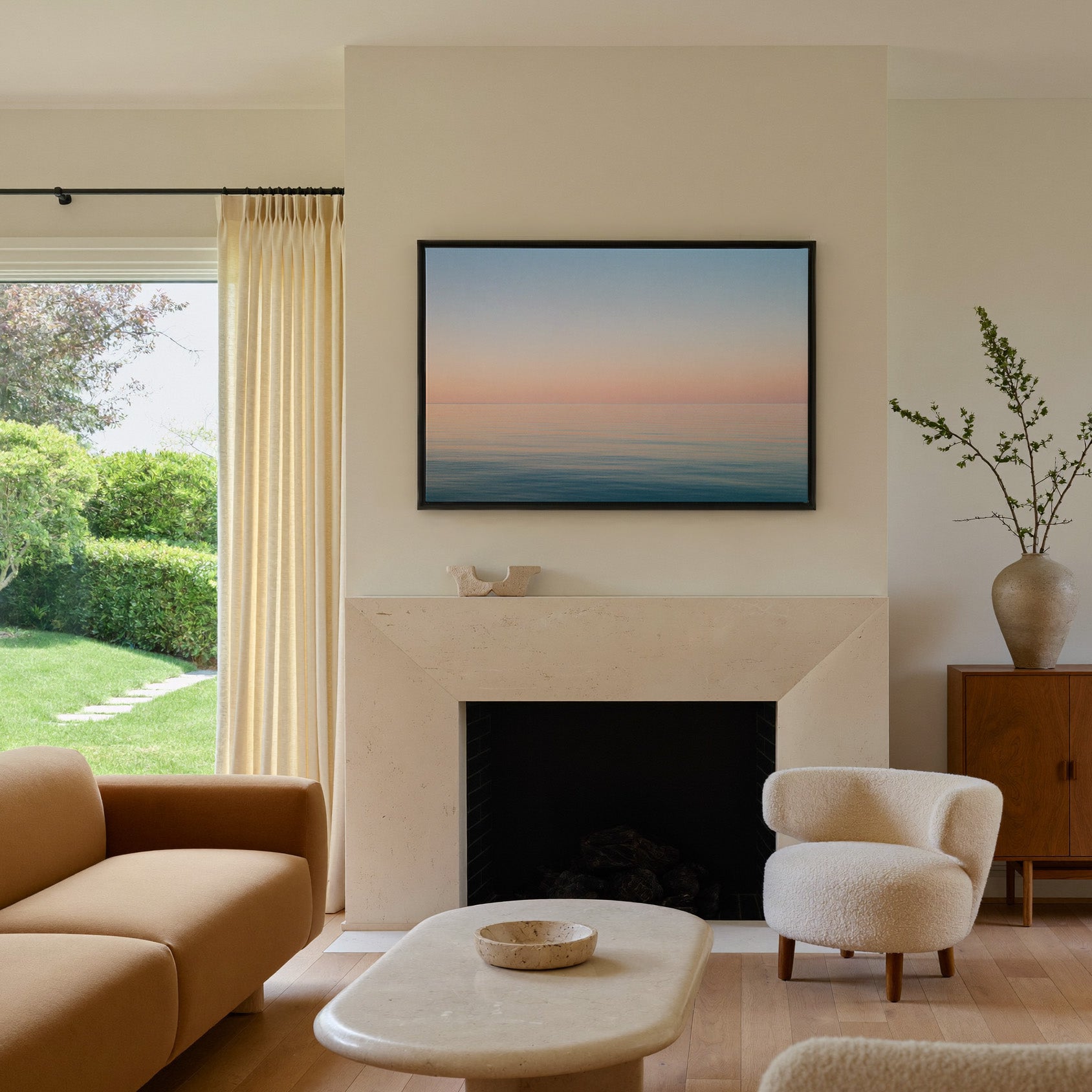 soft pastel sea and sky seascape canvas wall art in a black frame above a mantel