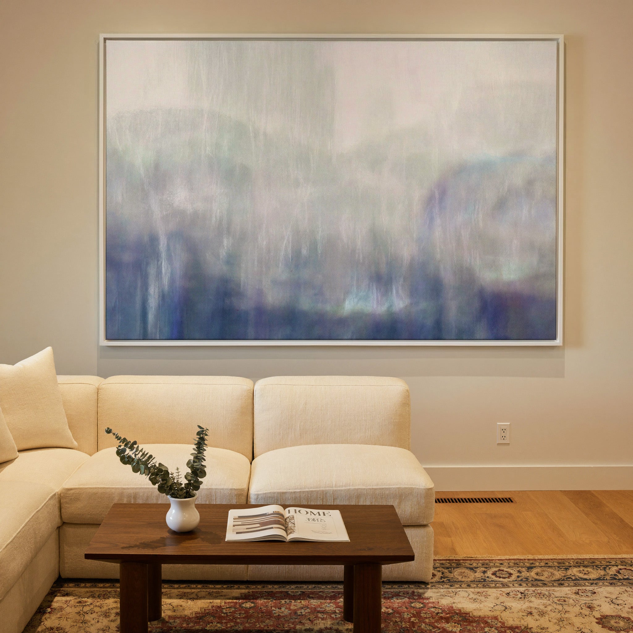 soft blue and violet abstract canvas wall art in a white frame in a styled room setting