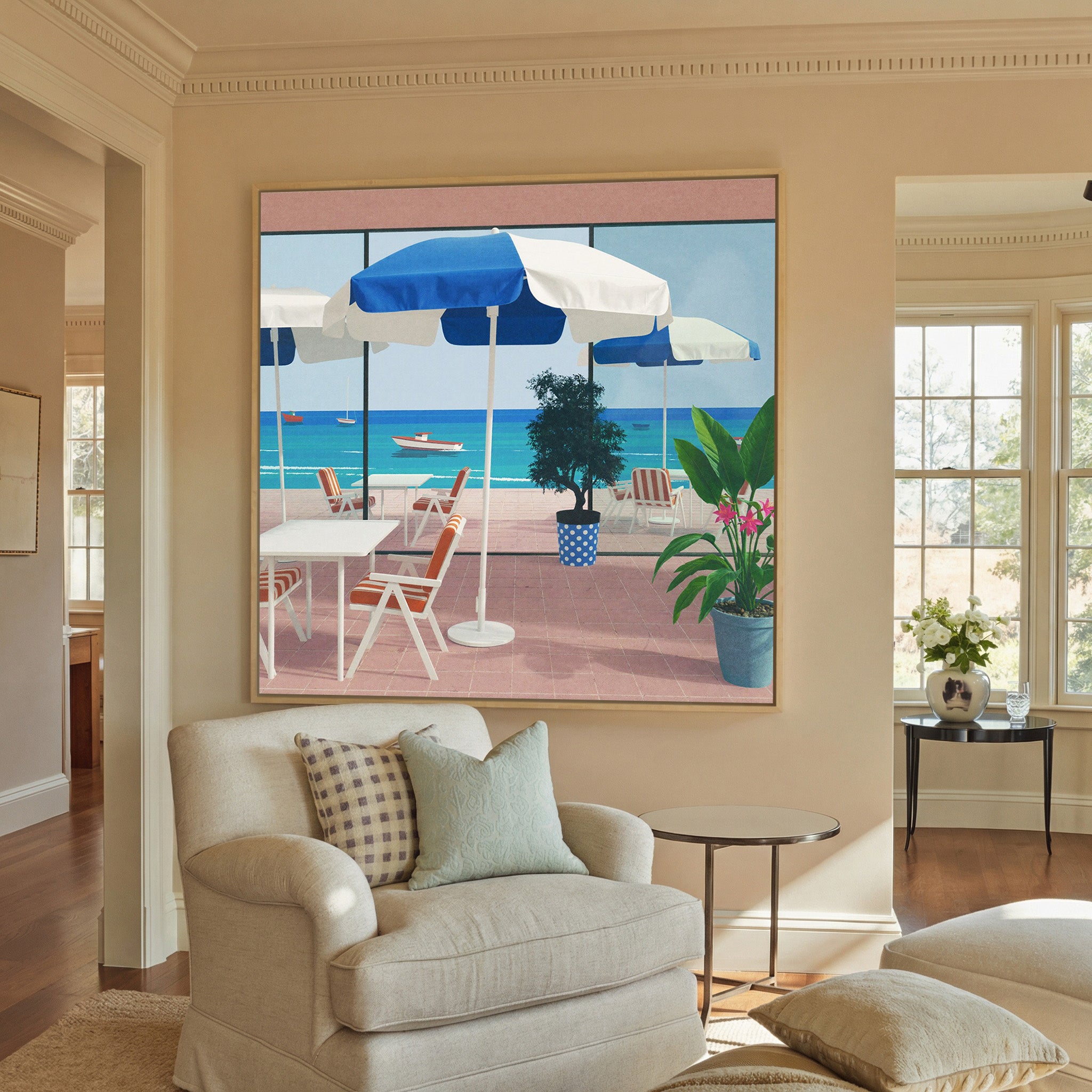 blue umbrellas and striped chairs by the sea canvas wall art in a natural wood frame in a styled room setting