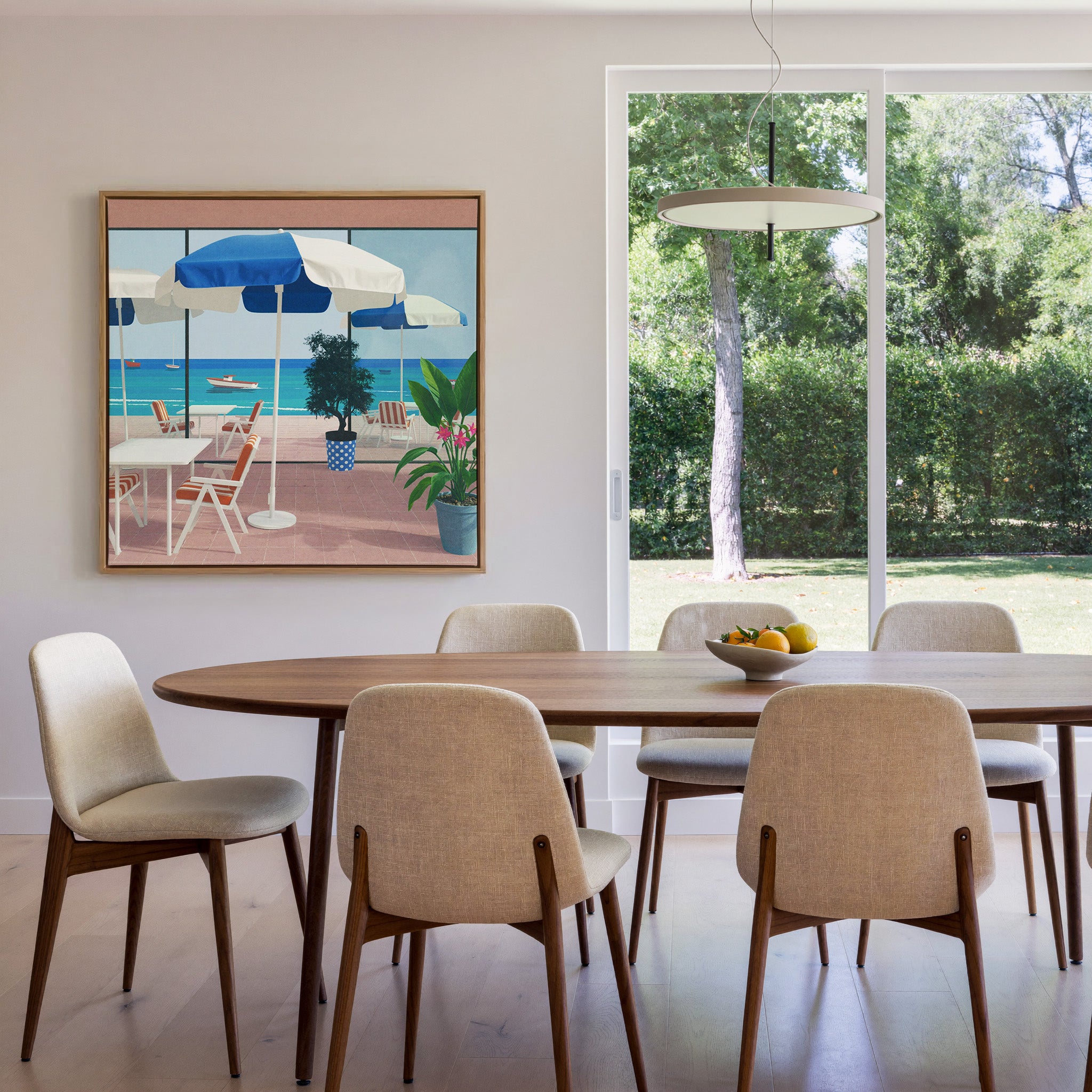 blue umbrellas and striped chairs by the sea canvas wall art in an oak frame in a dining room