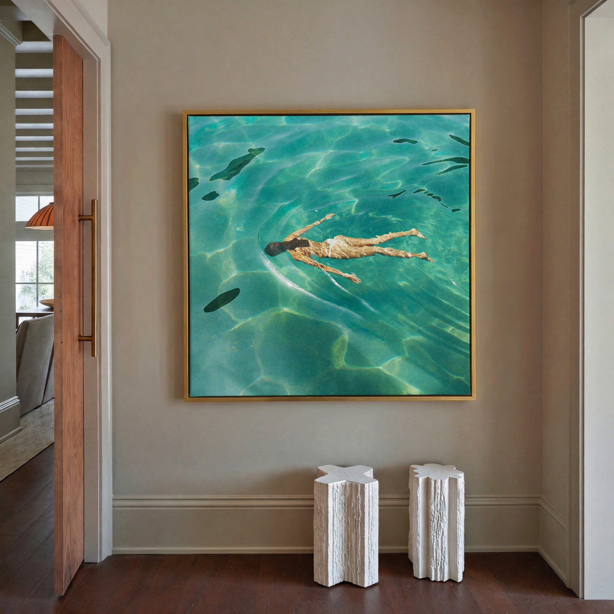 overhead swimmer in turquoise water canvas wall art in a gold frame in a styled room setting