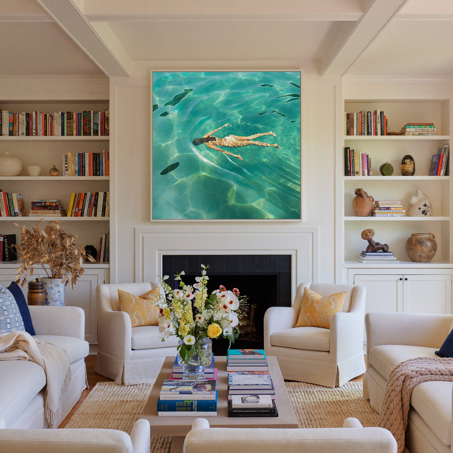 overhead swimmer in turquoise water canvas wall art in a white frame above a fireplace