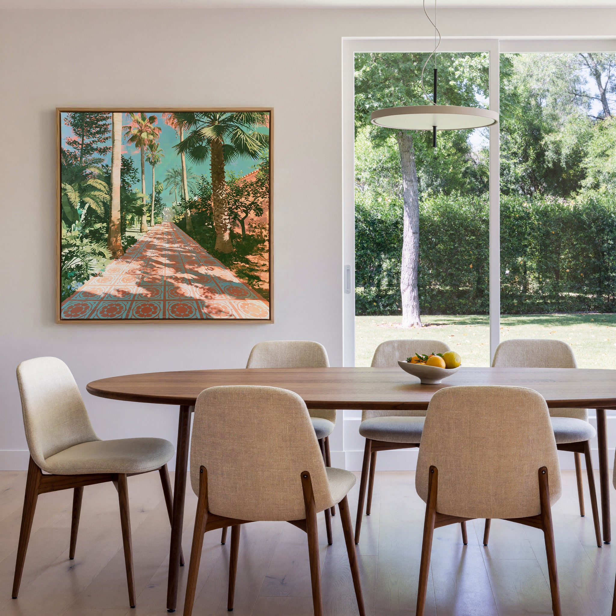 tall palms and patterned terracotta paving canvas wall art in an oak frame in a dining room
