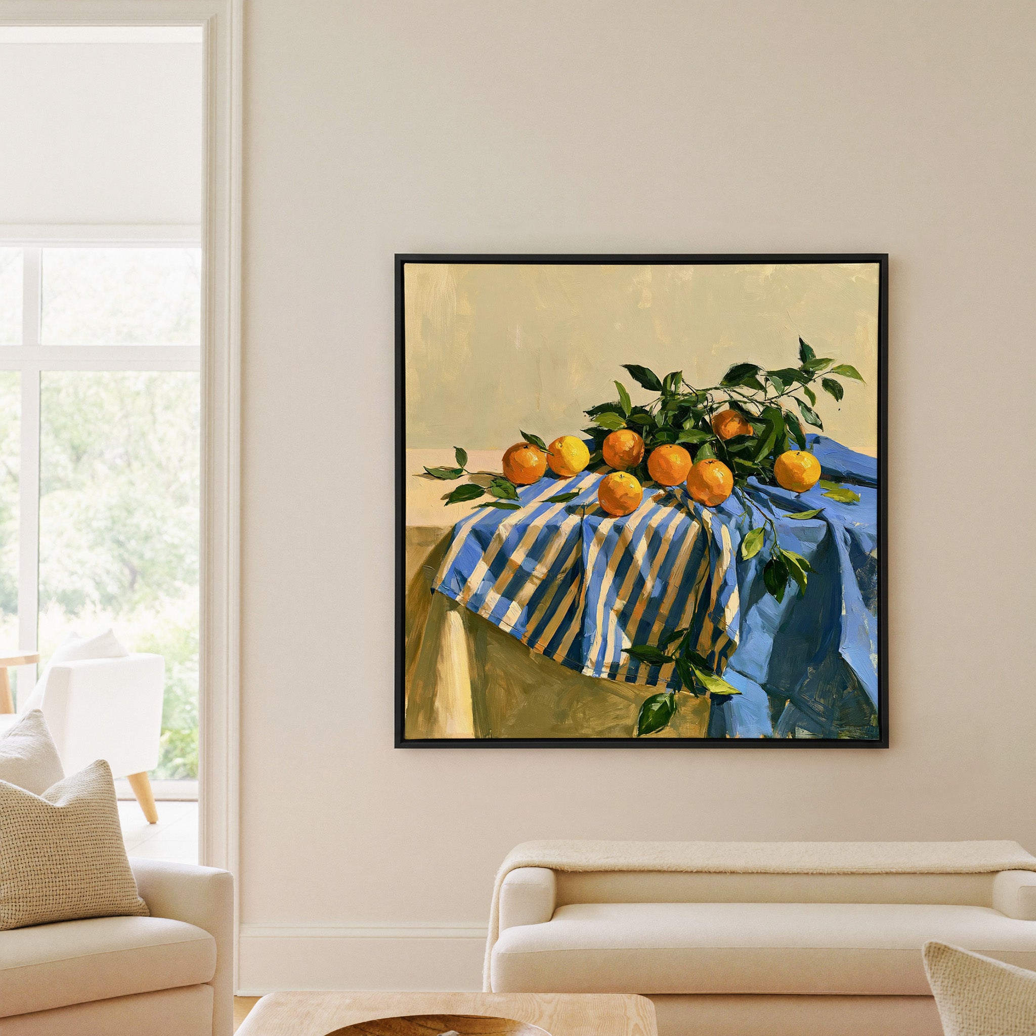 oranges on a blue striped cloth canvas wall art in a black frame in a living room