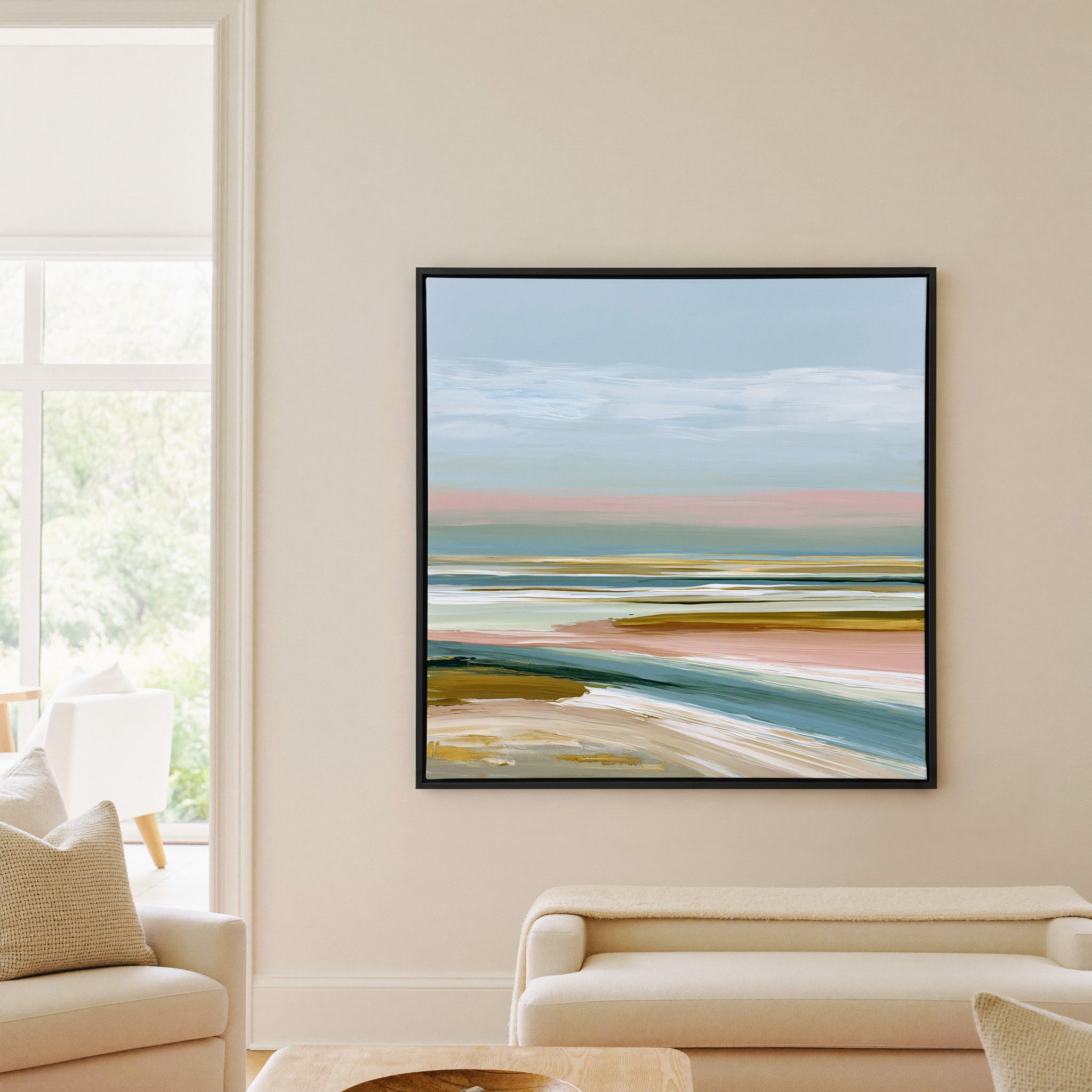 layered seafoam, blush, and sand bands canvas wall art in a black frame in a living room