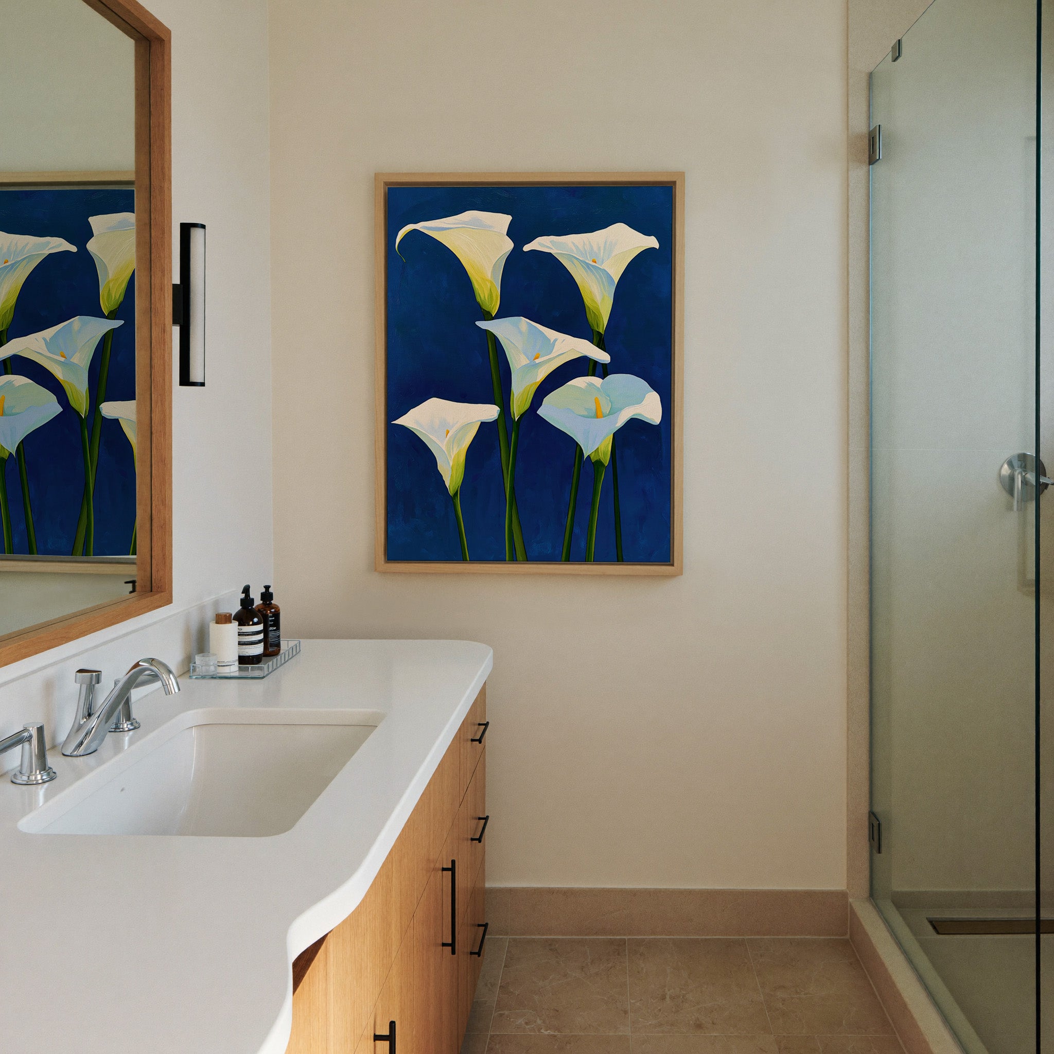 white calla lilies on deep cobalt blue canvas wall art in a natural wood frame in a styled room setting
