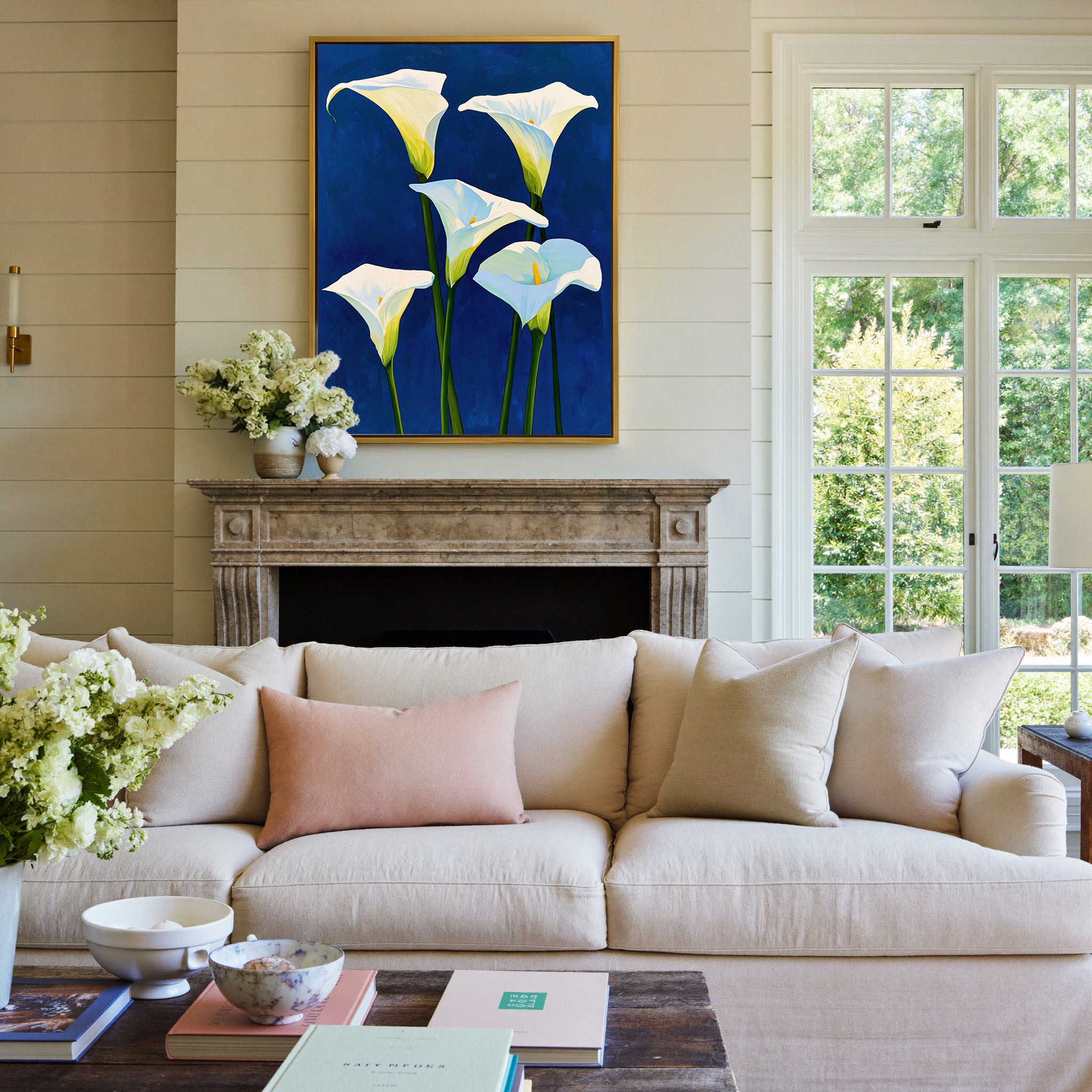 white calla lilies on deep cobalt blue canvas wall art in a gold frame above a mantel